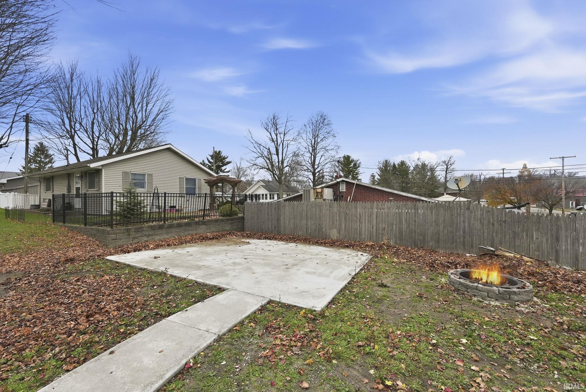 Fenced yard with a patio area and a fire pit