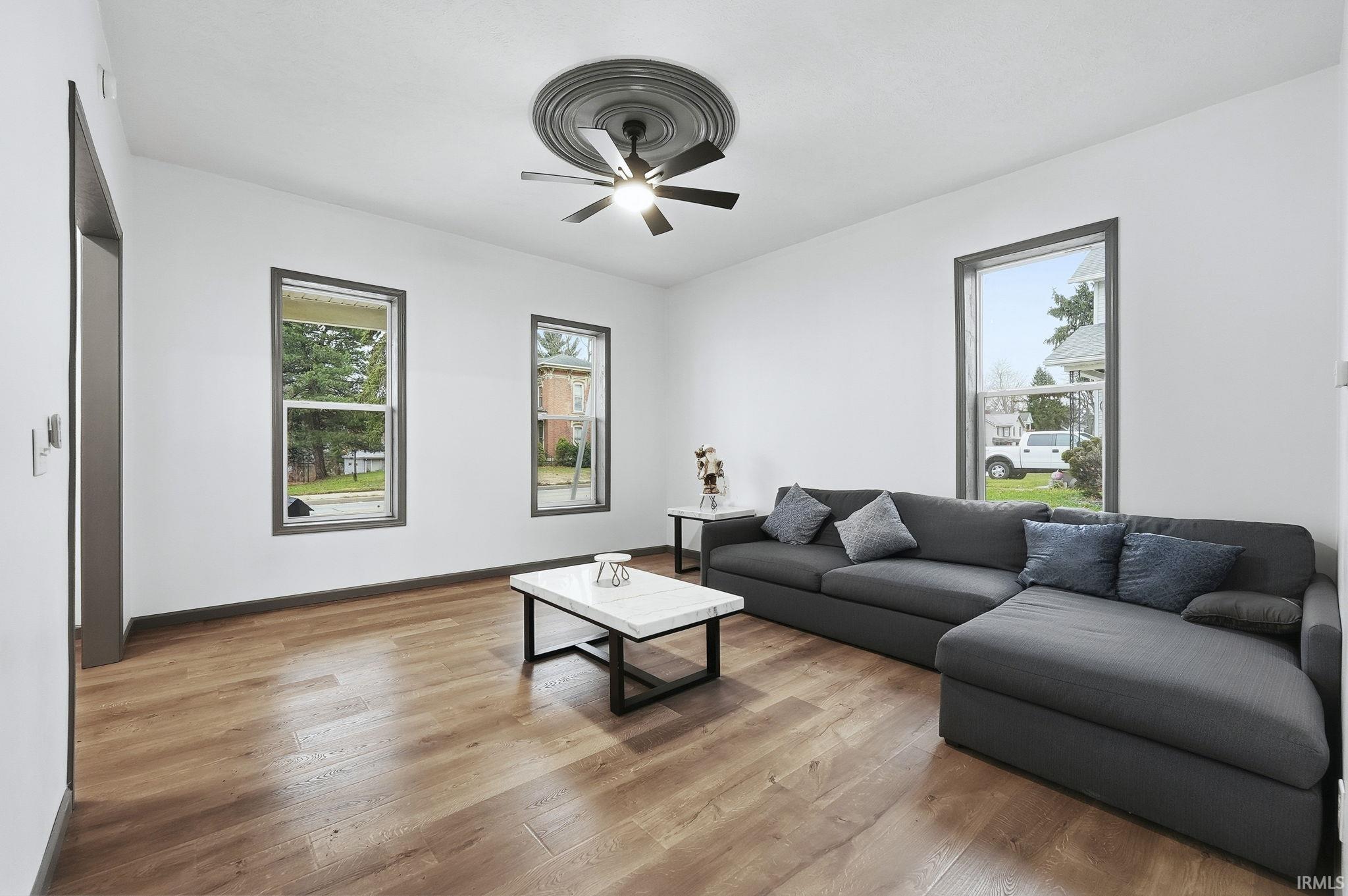 Living area with light wood-style flooring and a ceiling fan