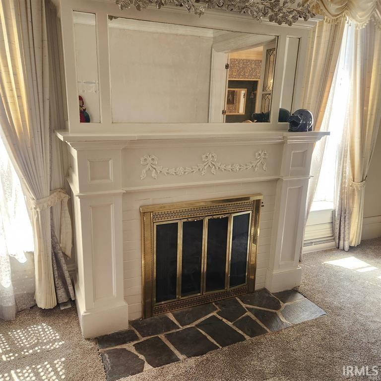 Detailed view of carpet floors and a glass covered fireplace