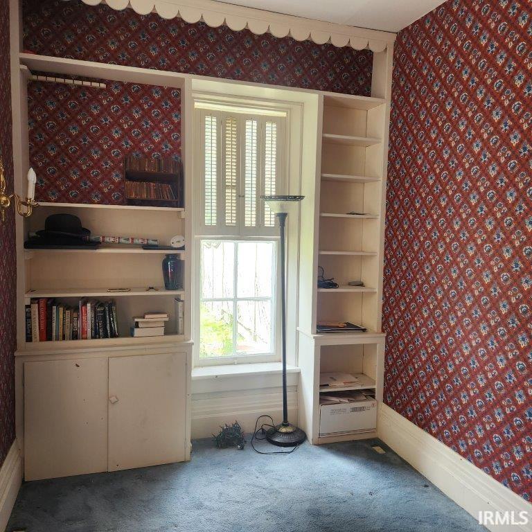 Spare room with wallpapered walls and carpet