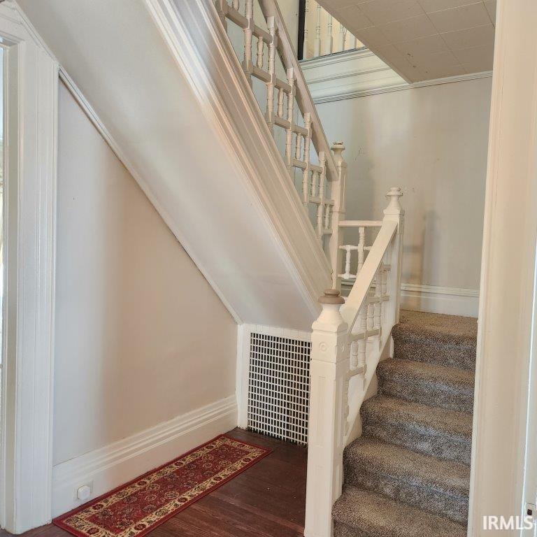 Stairs with wood finished floors and baseboards