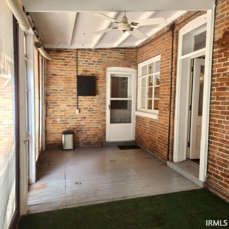 Unfurnished sunroom with beam ceiling