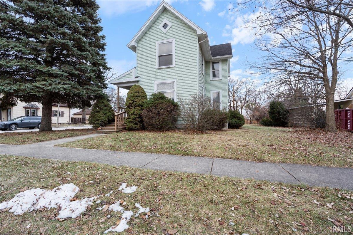 View of side of property with a lawn