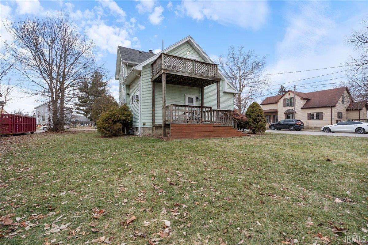 Rear view of house featuring a yard and a deck