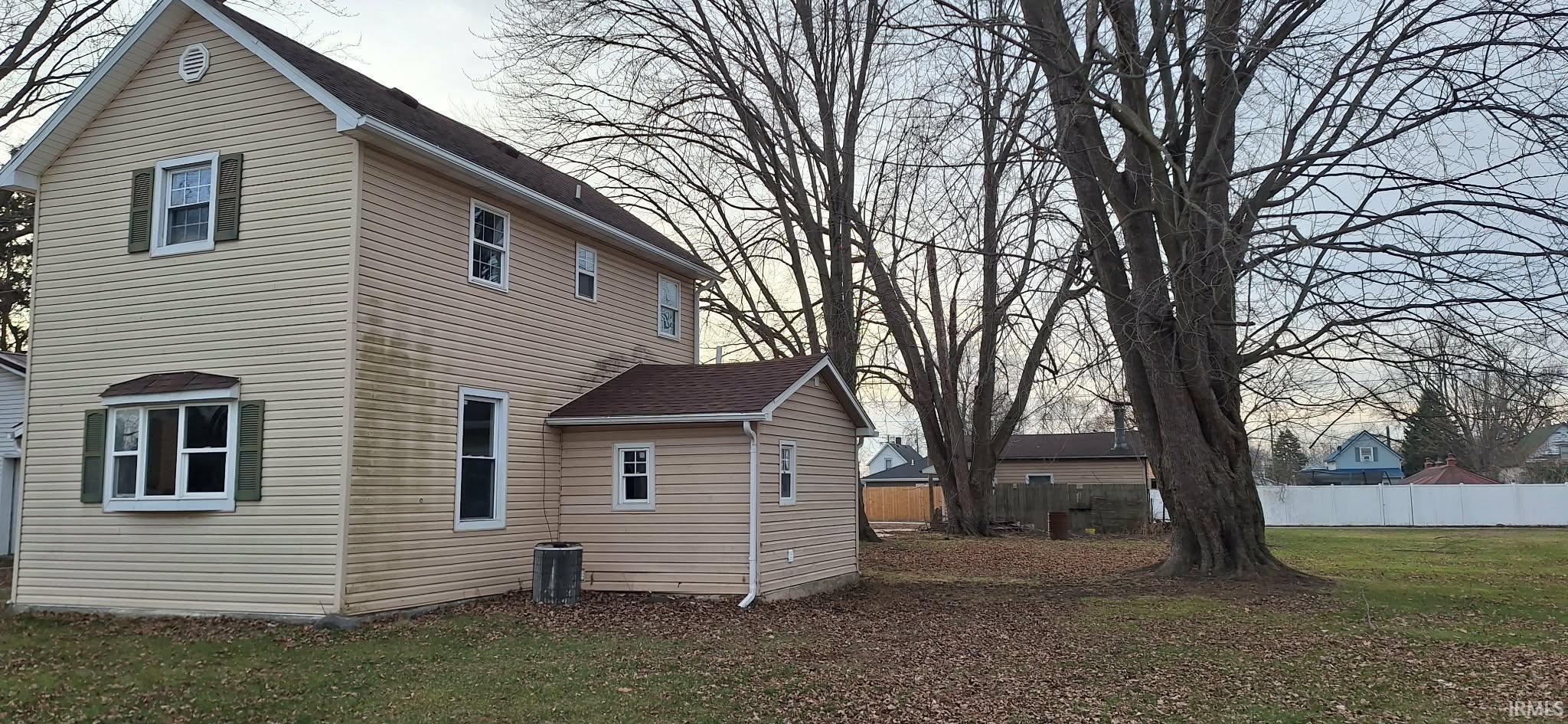 View of property exterior with a central AC unit and roof with shingles
