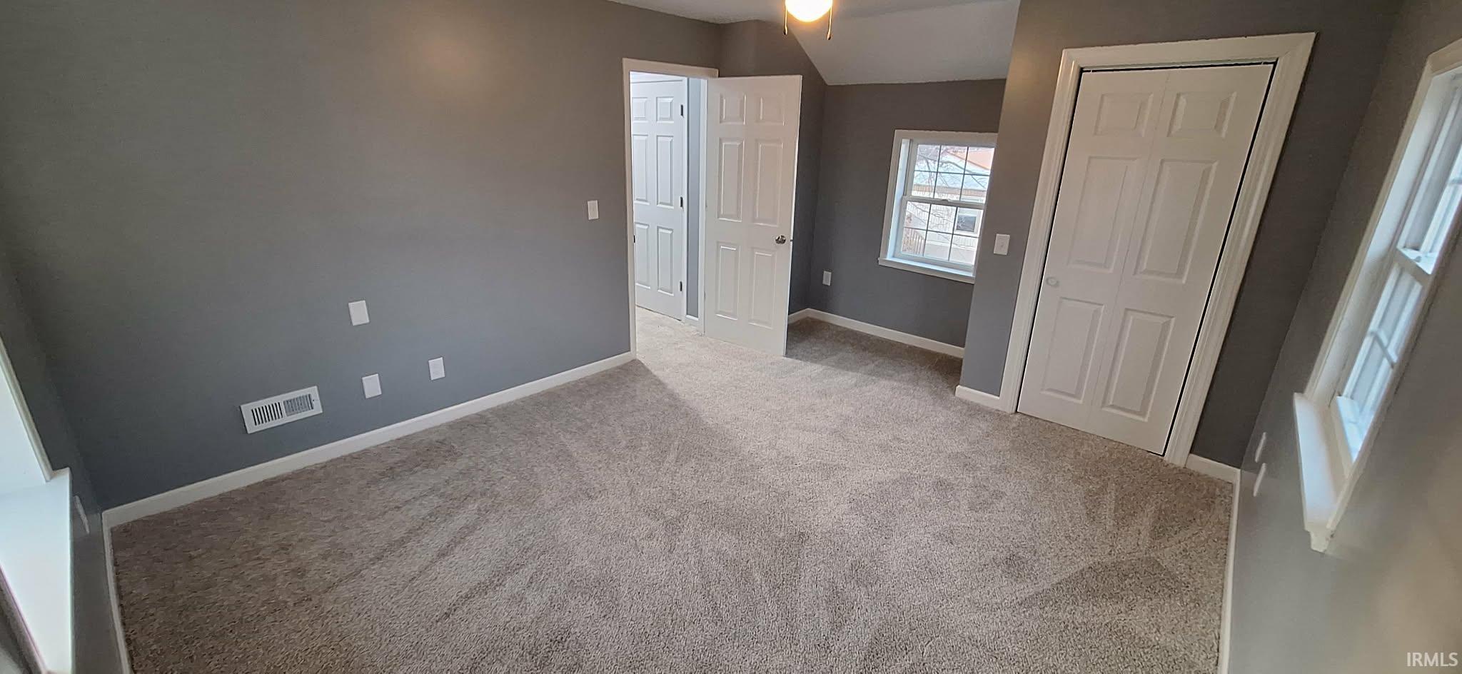 Unfurnished bedroom with light carpet and a closet