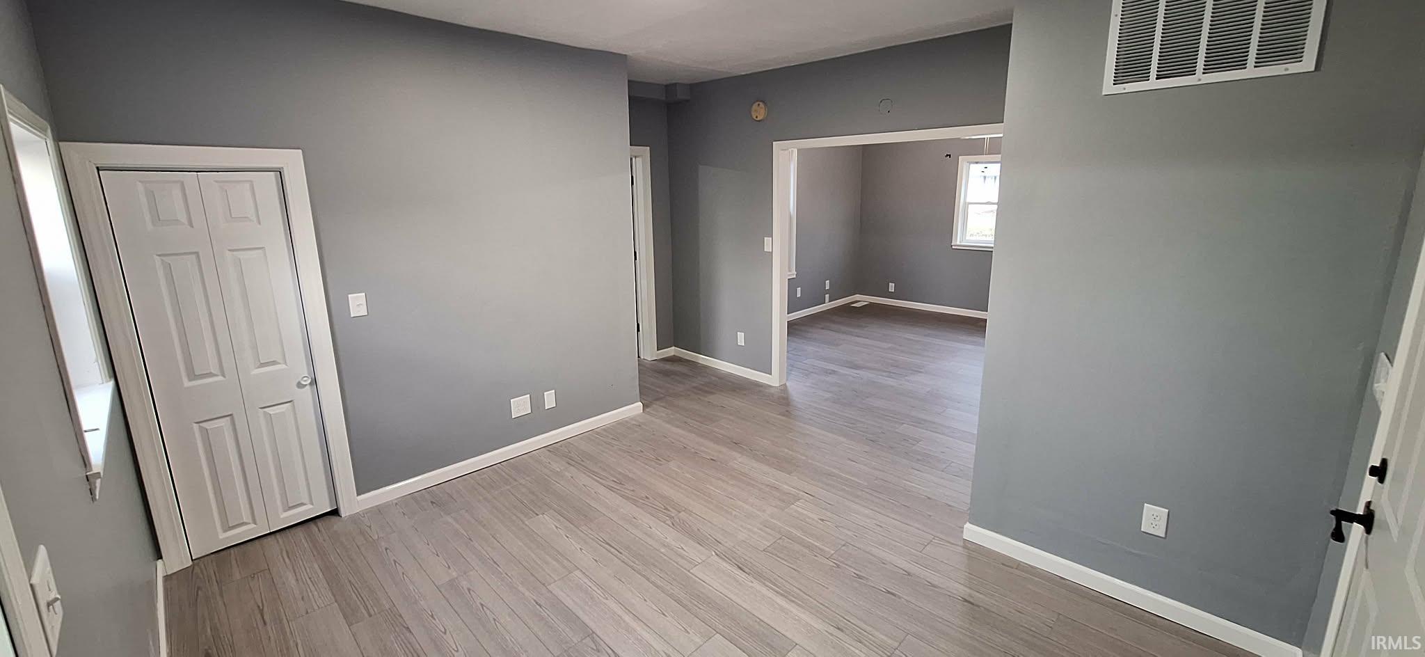 Unfurnished room featuring baseboards and light wood finished floors
