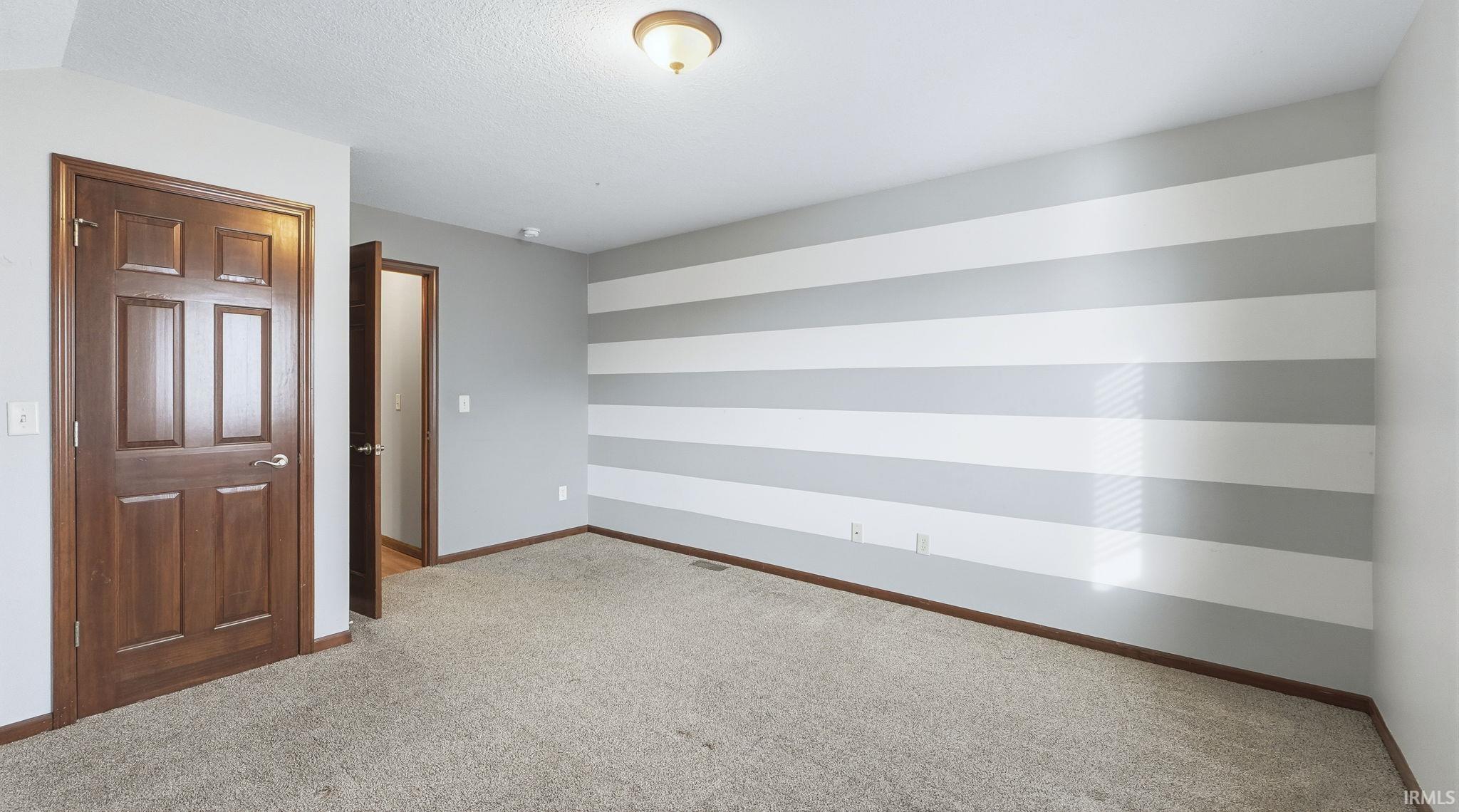 Empty room with carpet flooring and baseboards