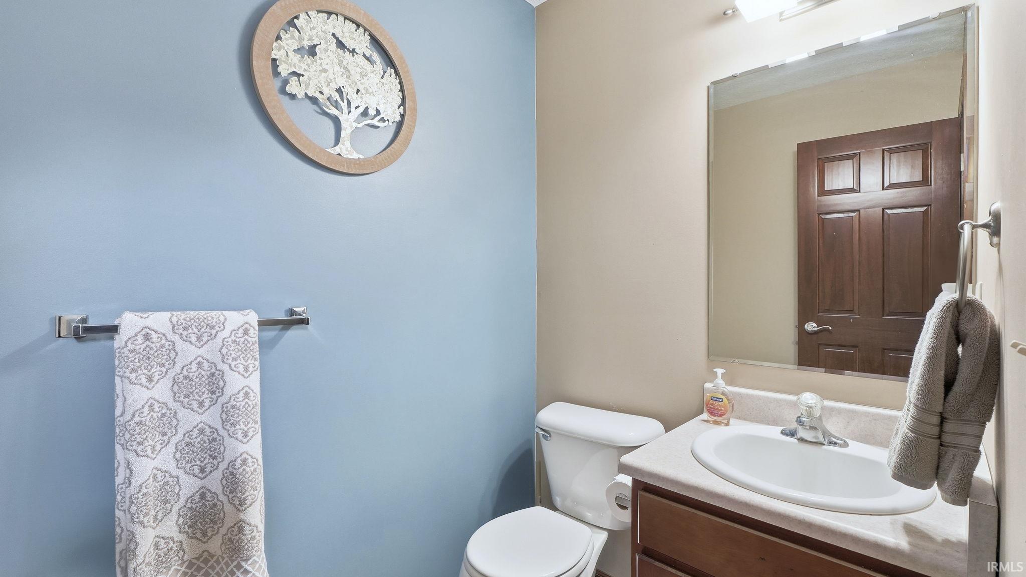 Half bath featuring vanity and toilet