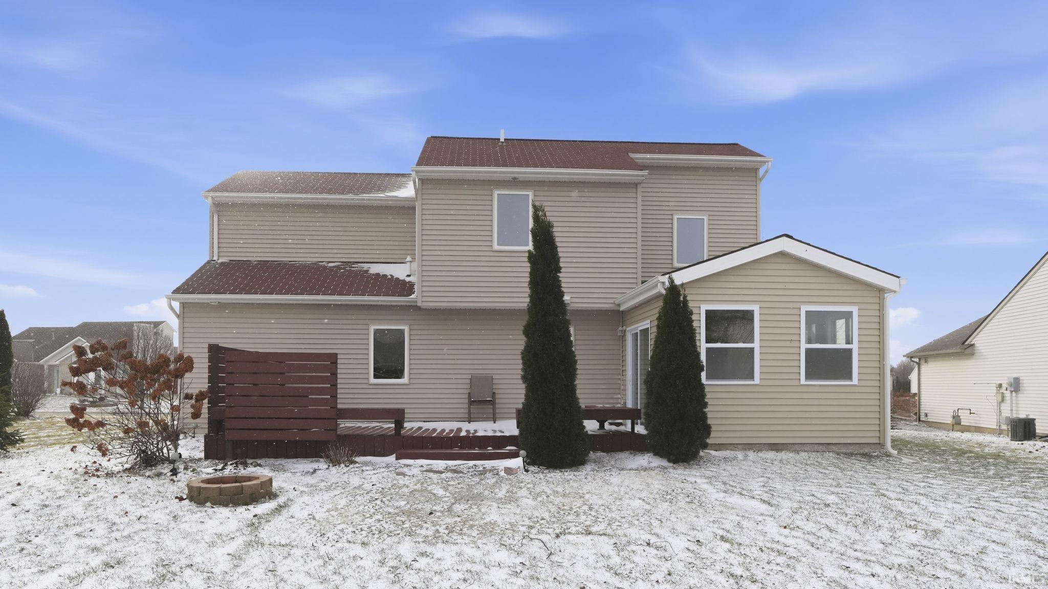 Snow covered house featuring a deck, an outdoor fire pit, and a shingled roof
