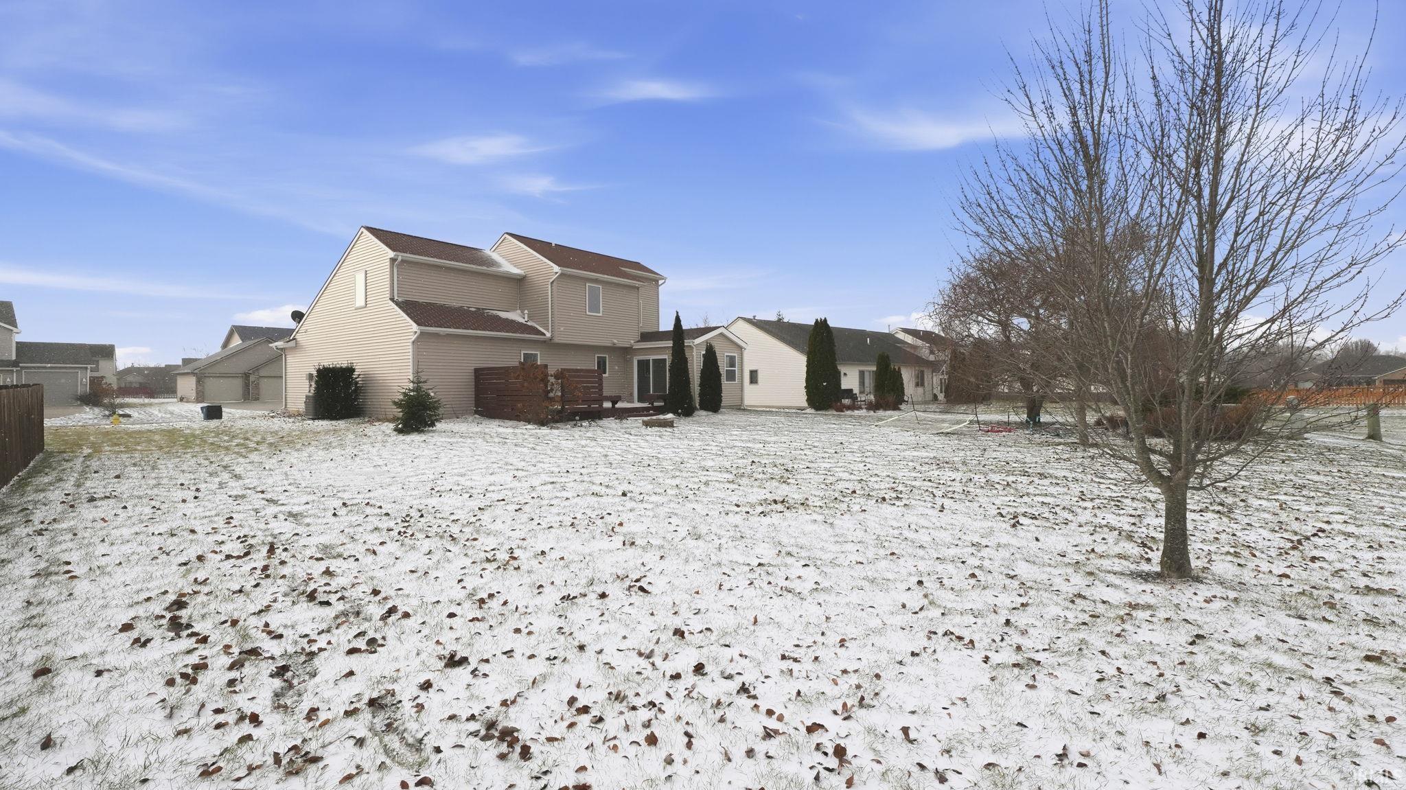 View of snow covered back of property