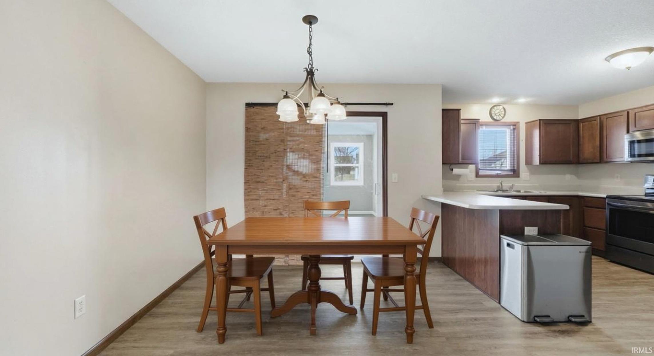 Dining space with light wood-type flooring and a chandelier