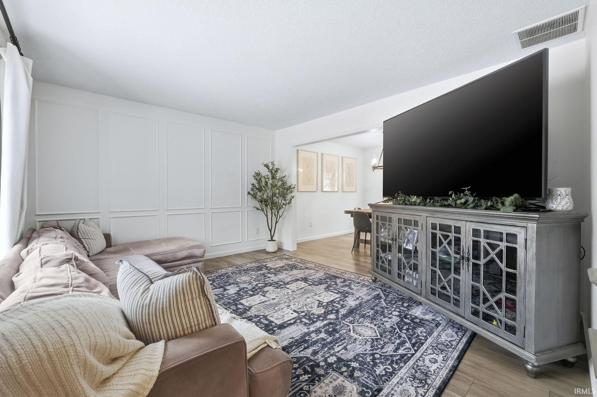 Living area with a decorative wall and light wood-type flooring