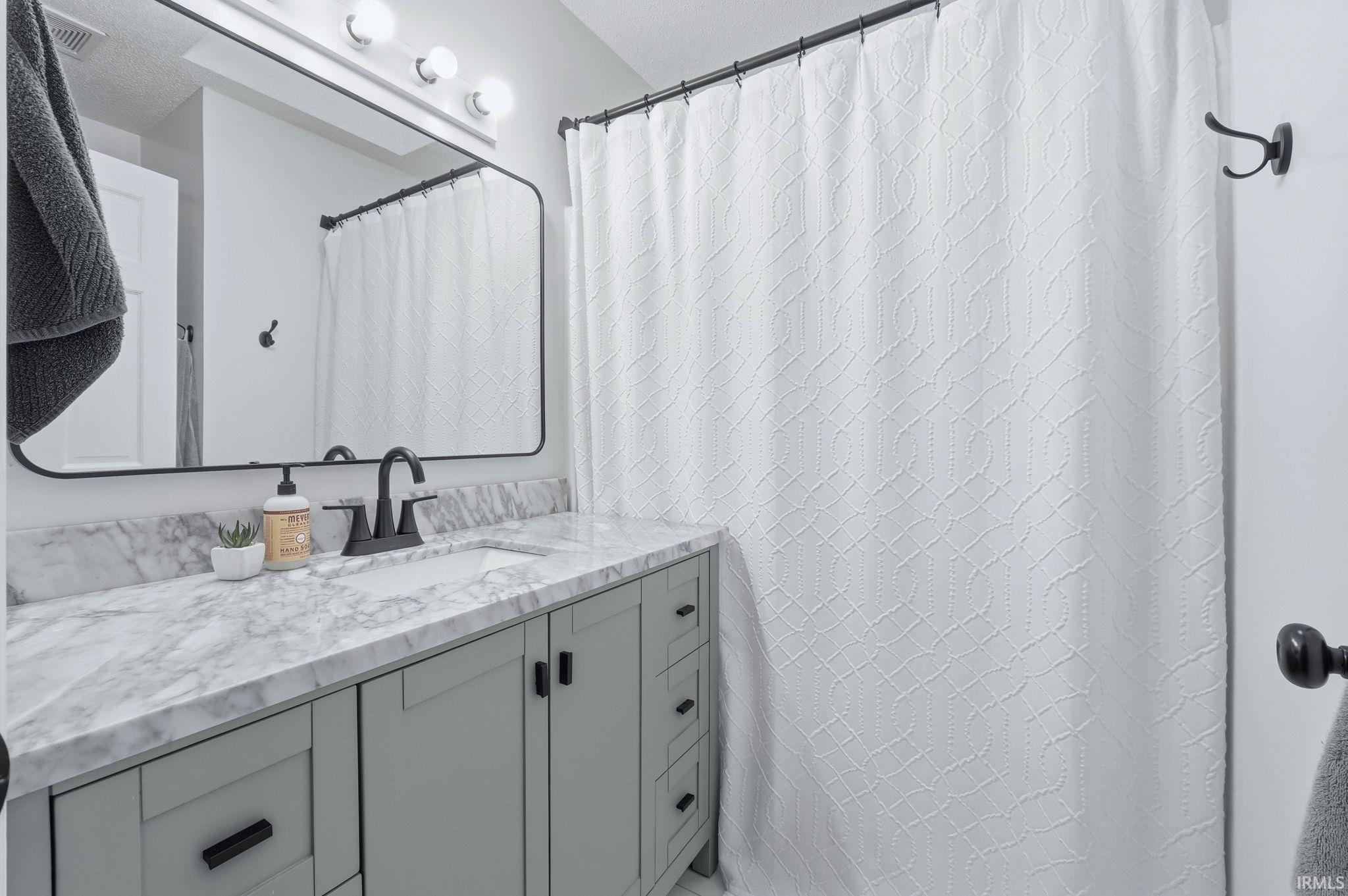Bathroom with vanity and a shower with shower curtain