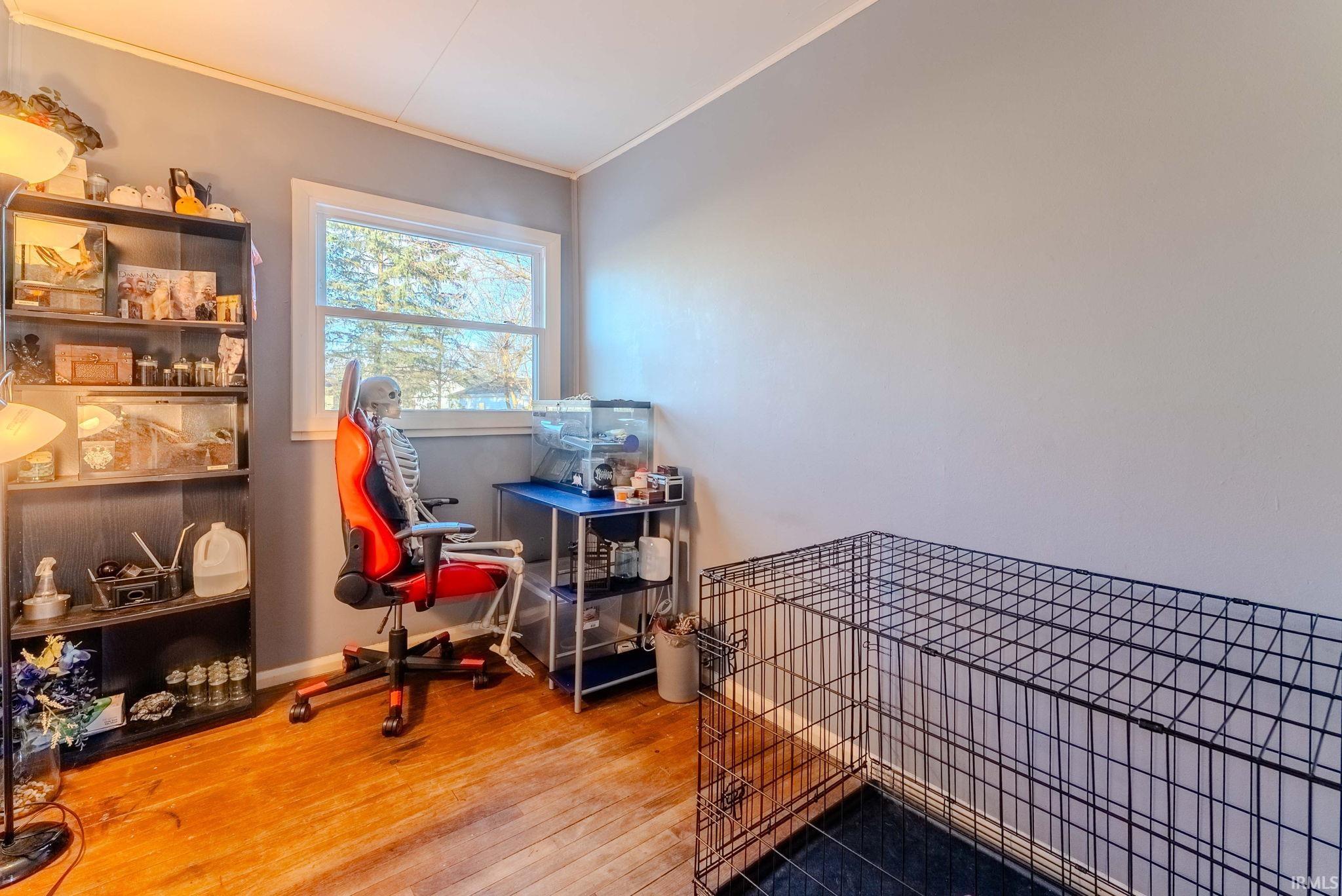 Bedroom with crown molding and hardwood / wood-style flooring