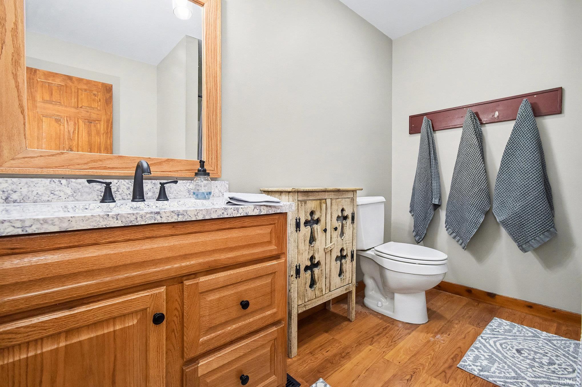Half bathroom featuring vanity and light wood-style flooring