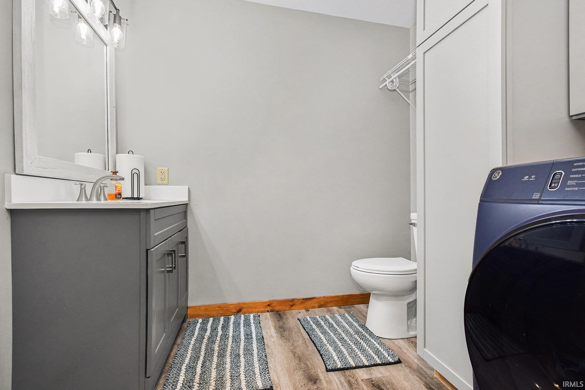 Bathroom featuring washer / clothes dryer, vanity, and light wood-type flooring