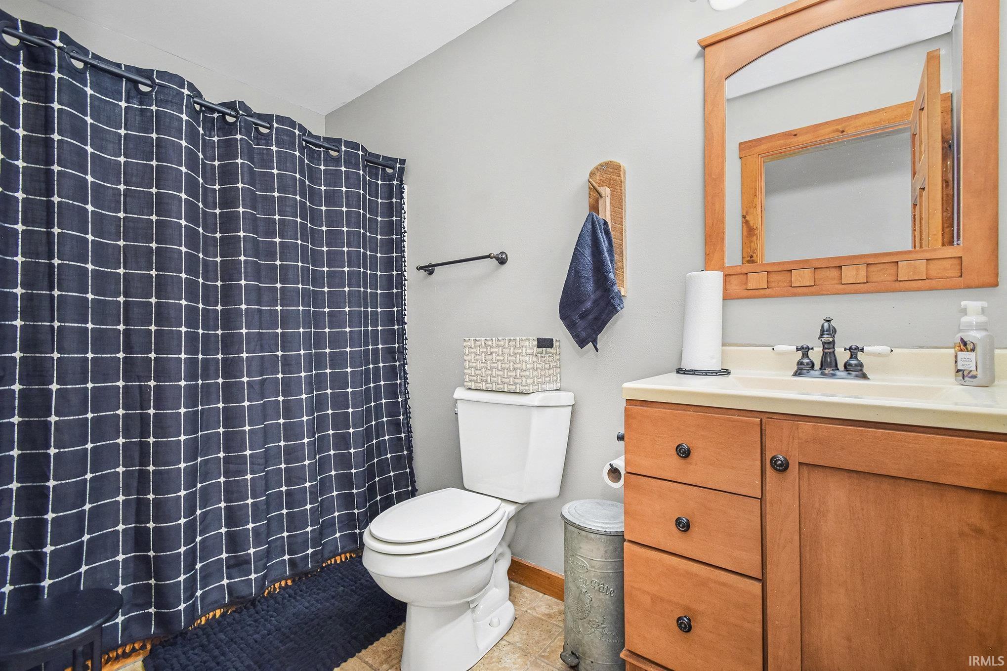 Bathroom featuring vanity, a shower with shower curtain, and light tile patterned floors
