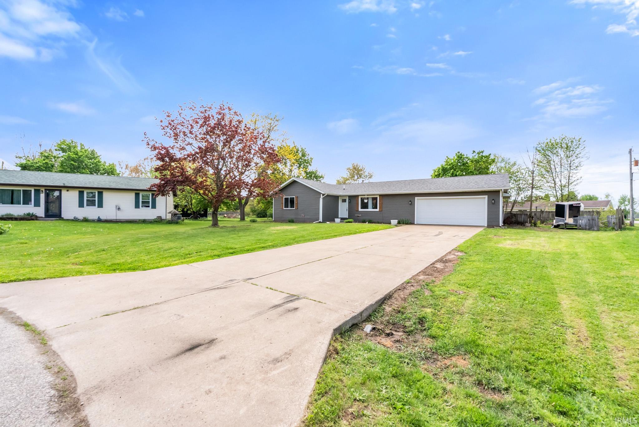 Single story home with concrete driveway, a front lawn, and a garage
