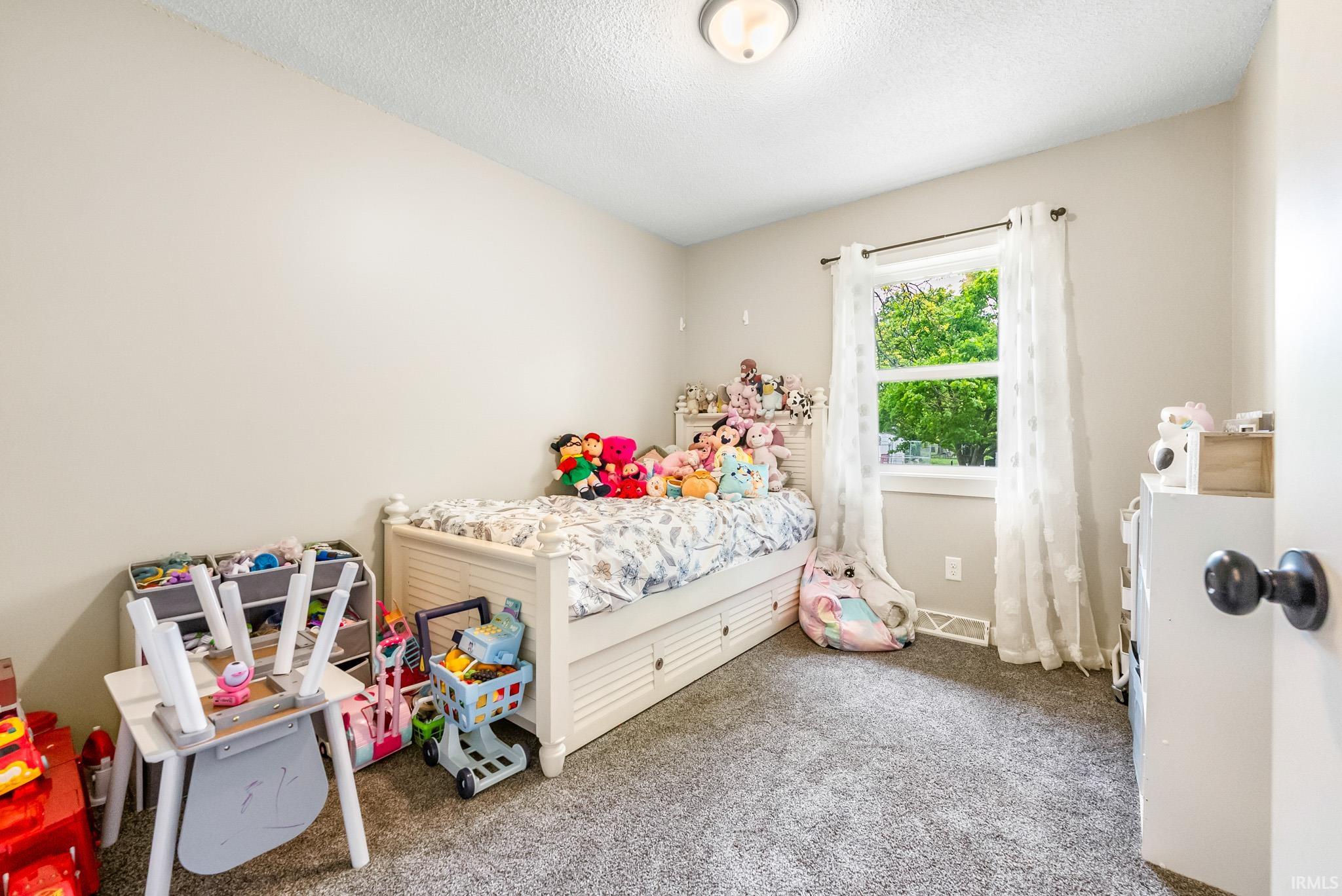 Carpeted bedroom featuring a textured ceiling
