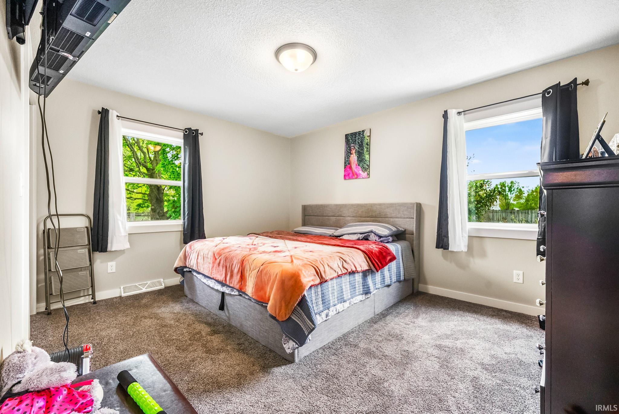 Bedroom with carpet floors and a textured ceiling