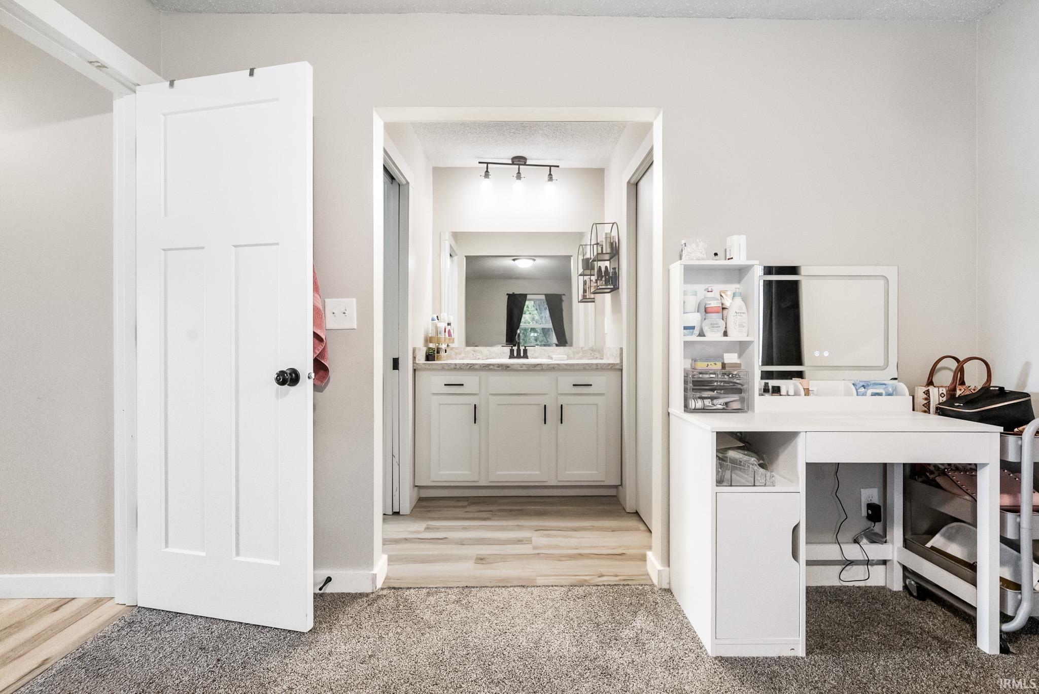 Bathroom featuring vanity, light carpet, and a textured ceiling