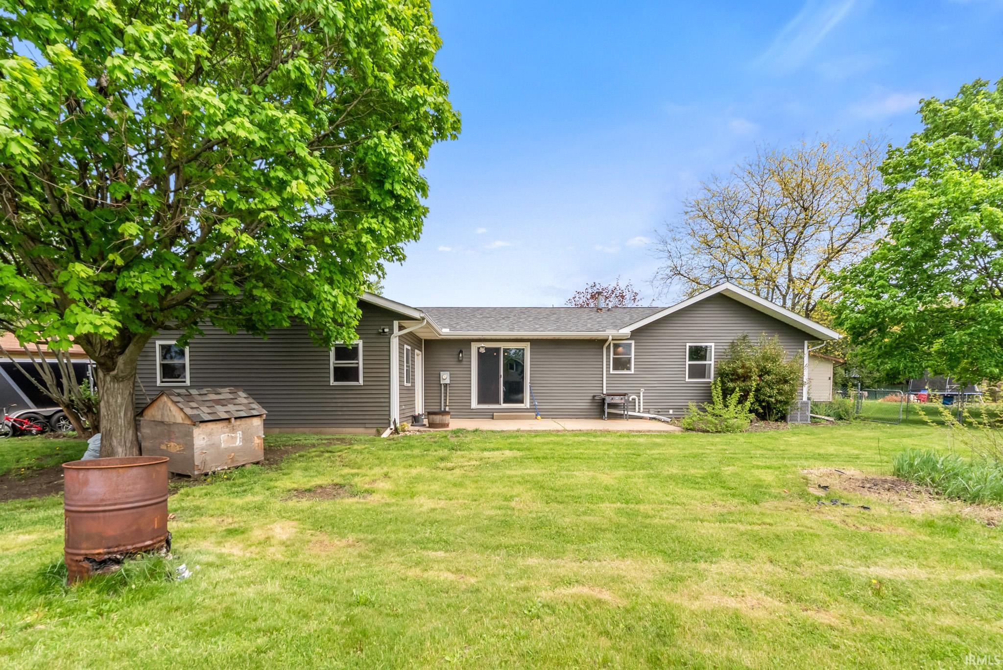 Back of house featuring a patio and roof with shingles