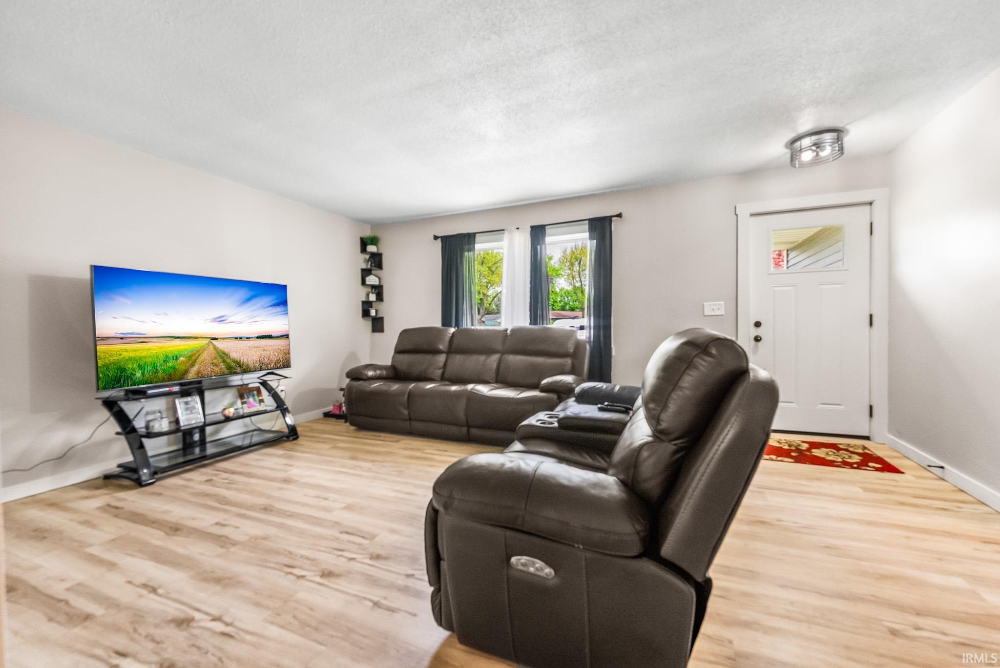 Living room with light wood finished floors and a textured ceiling