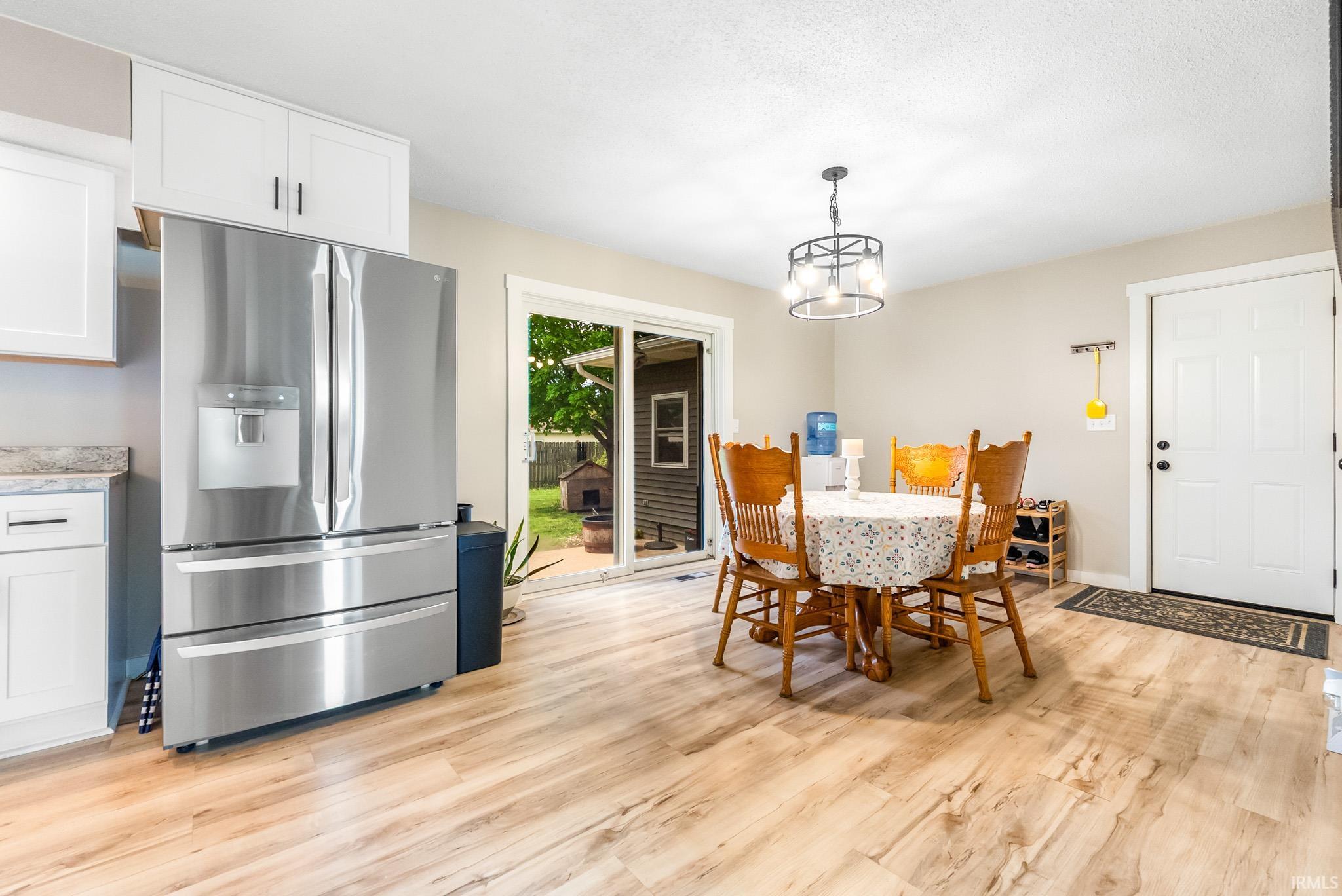 Dining room featuring light wood finished floors and a chandelier