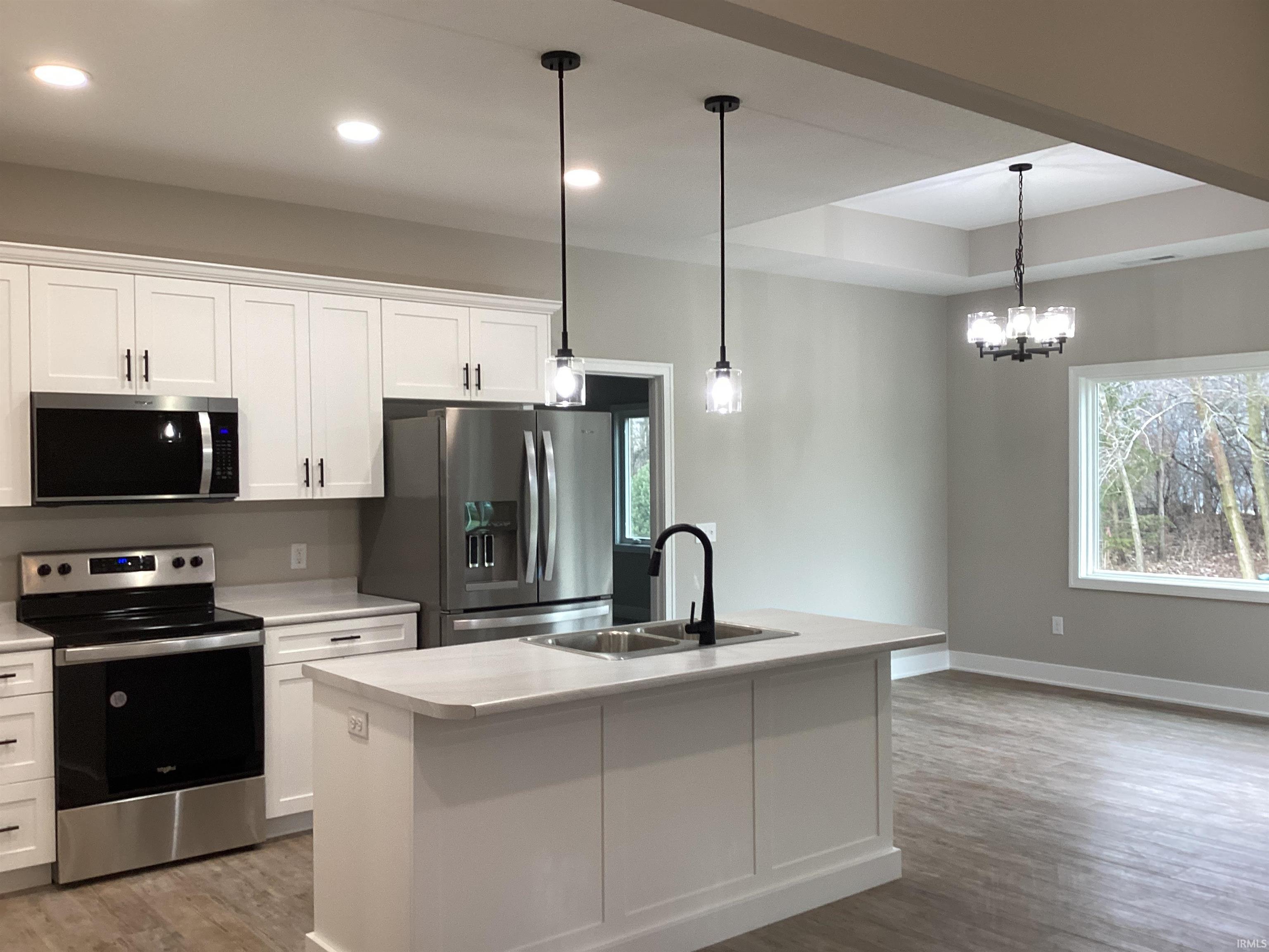 Kitchen with appliances with stainless steel finishes, white cabinets, light wood-style floors, and recessed lighting