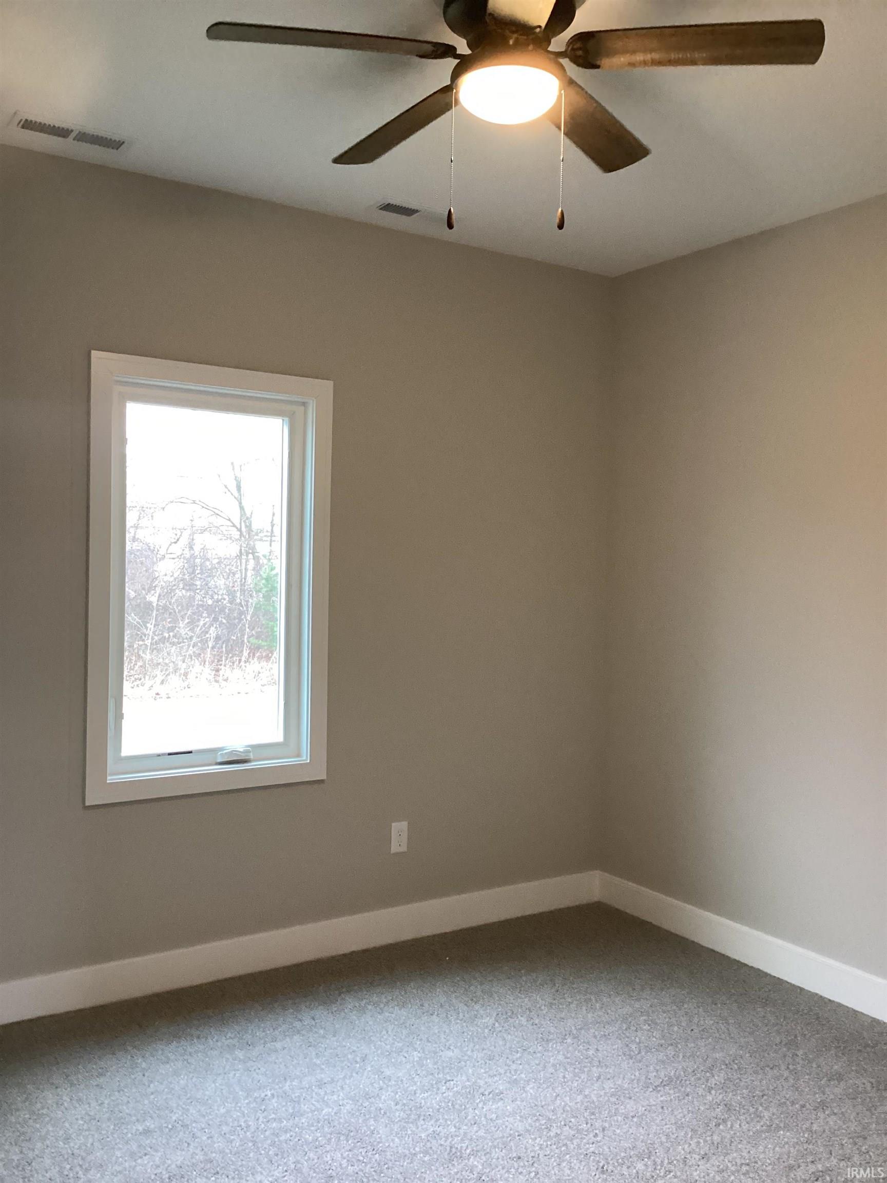 Unfurnished room with carpet and a ceiling fan