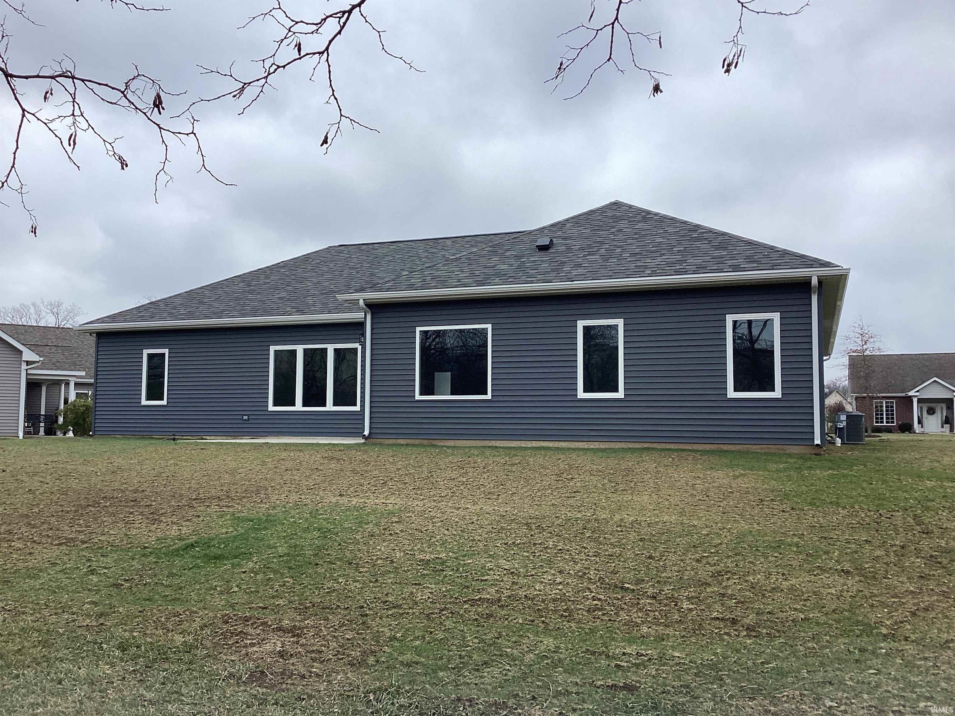 Back of house featuring a yard and roof with shingles