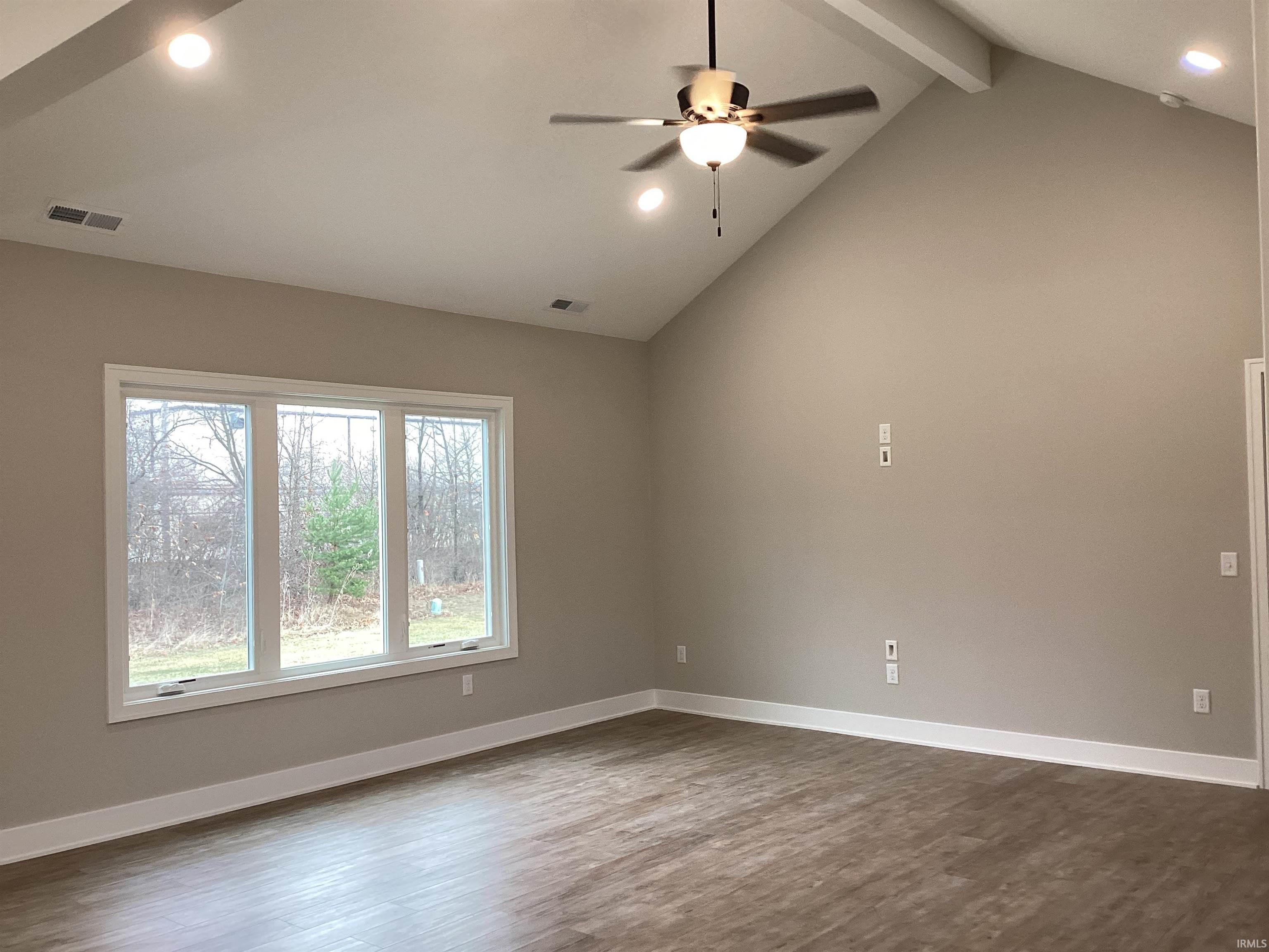 Empty room featuring dark wood finished floors, recessed lighting, beam ceiling, ceiling fan, and high vaulted ceiling