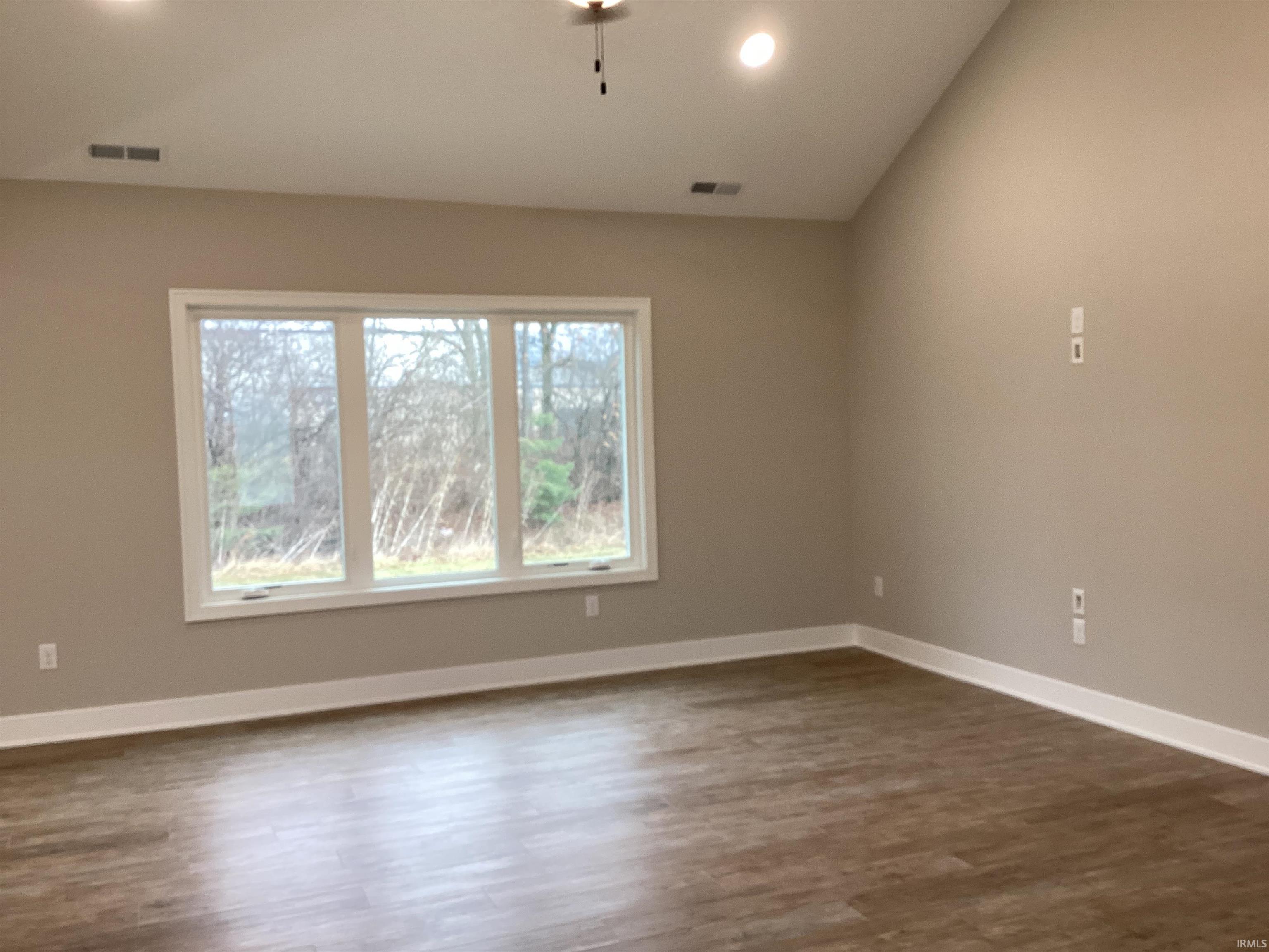 Empty room featuring dark wood-type flooring and recessed lighting
