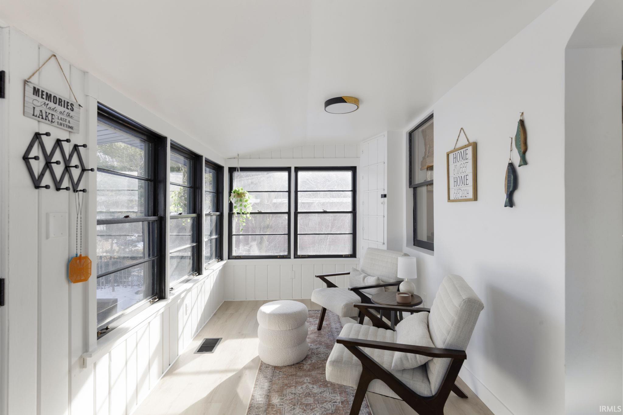 Sunroom / solarium featuring vaulted ceiling and wood finished floors