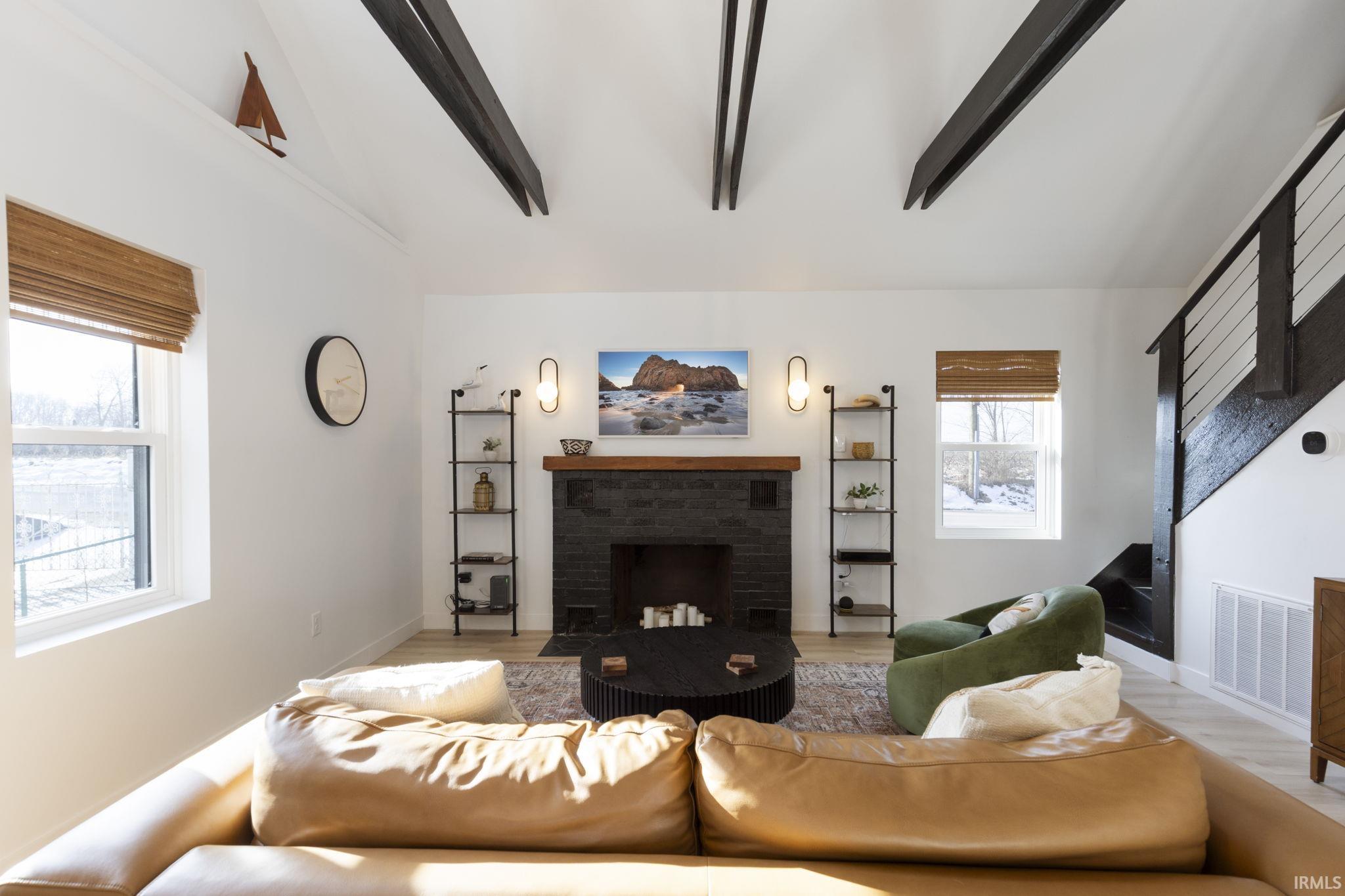 Living area with a brick fireplace and wood finished floors