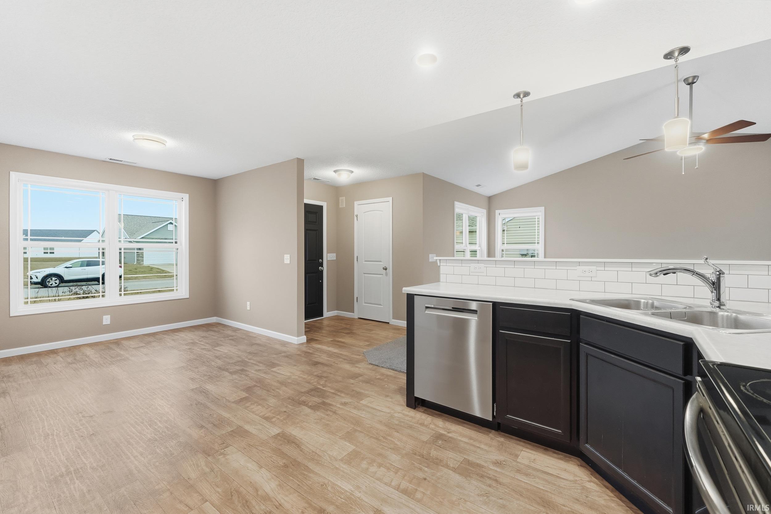 Kitchen with pendant lighting, stainless steel dishwasher, tasteful backsplash, a ceiling fan, and open floor plan