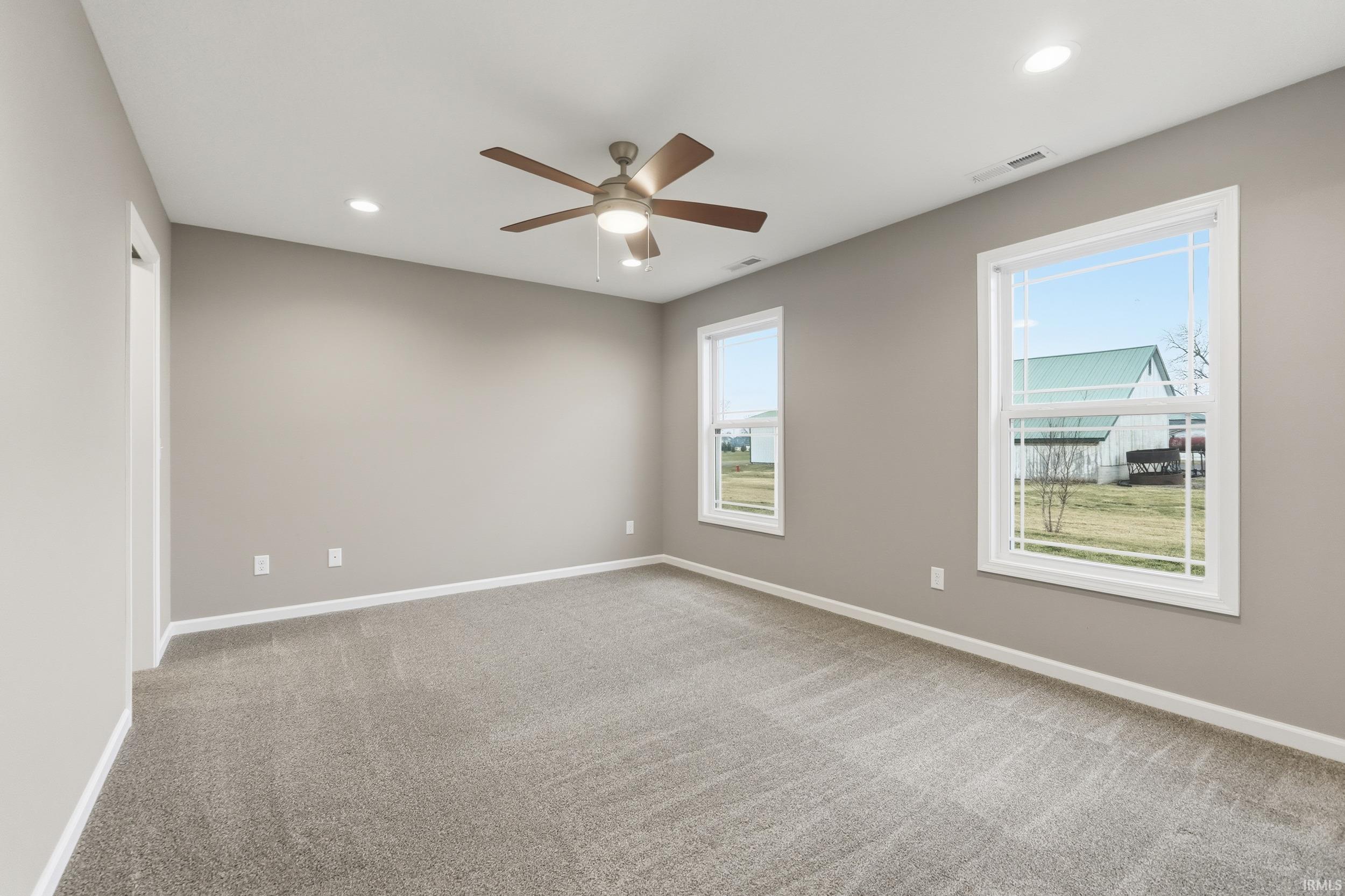 Empty room with light colored carpet, recessed lighting, and ceiling fan