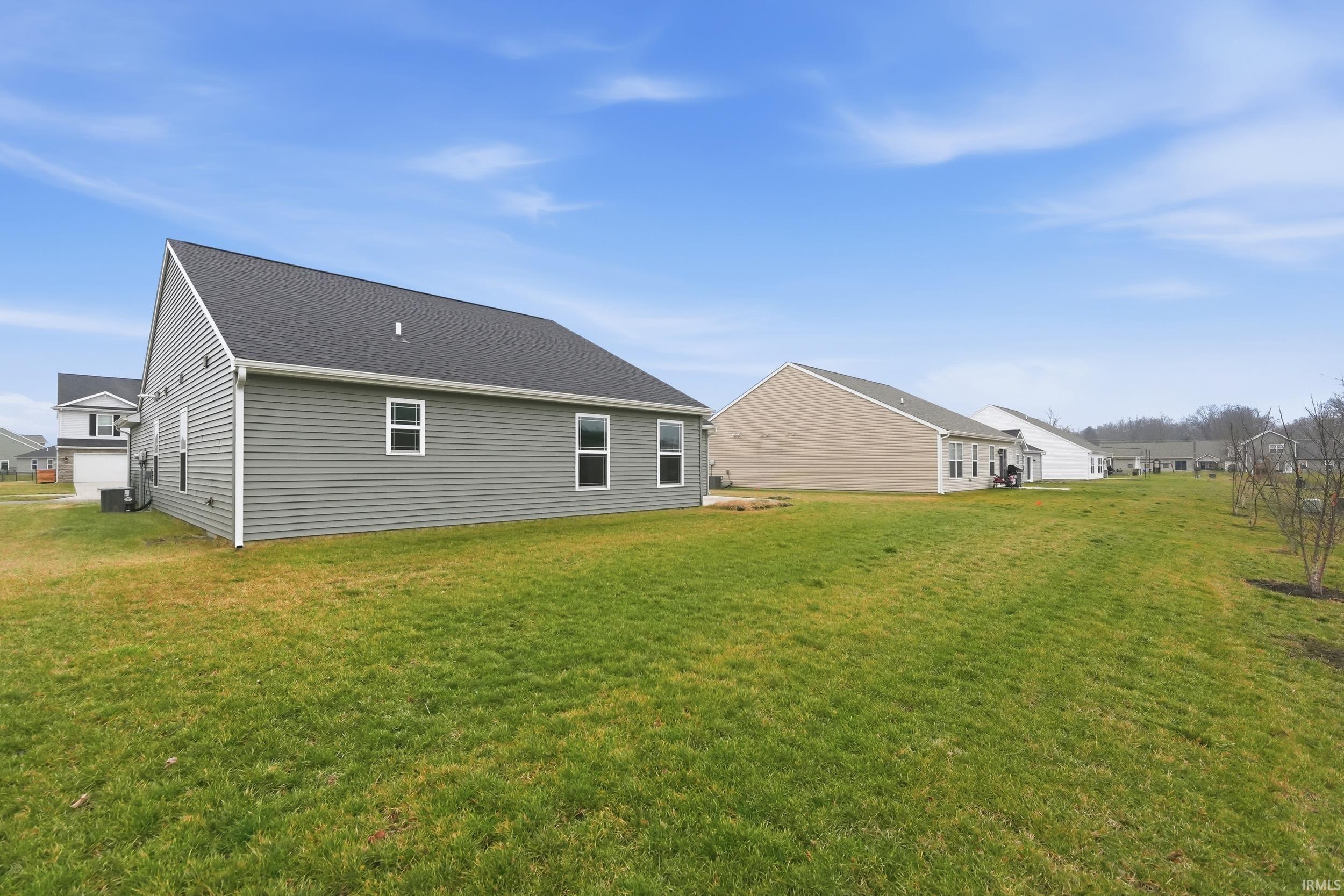 Back of house featuring a yard and a shingled roof