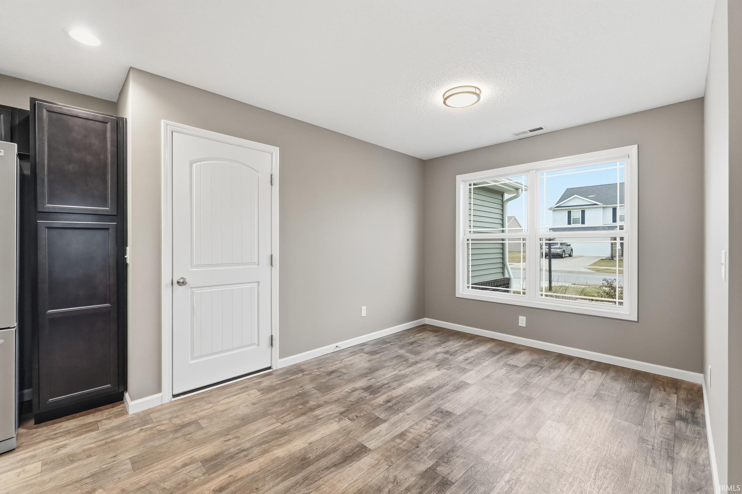 Unfurnished bedroom with baseboards and light wood-type flooring