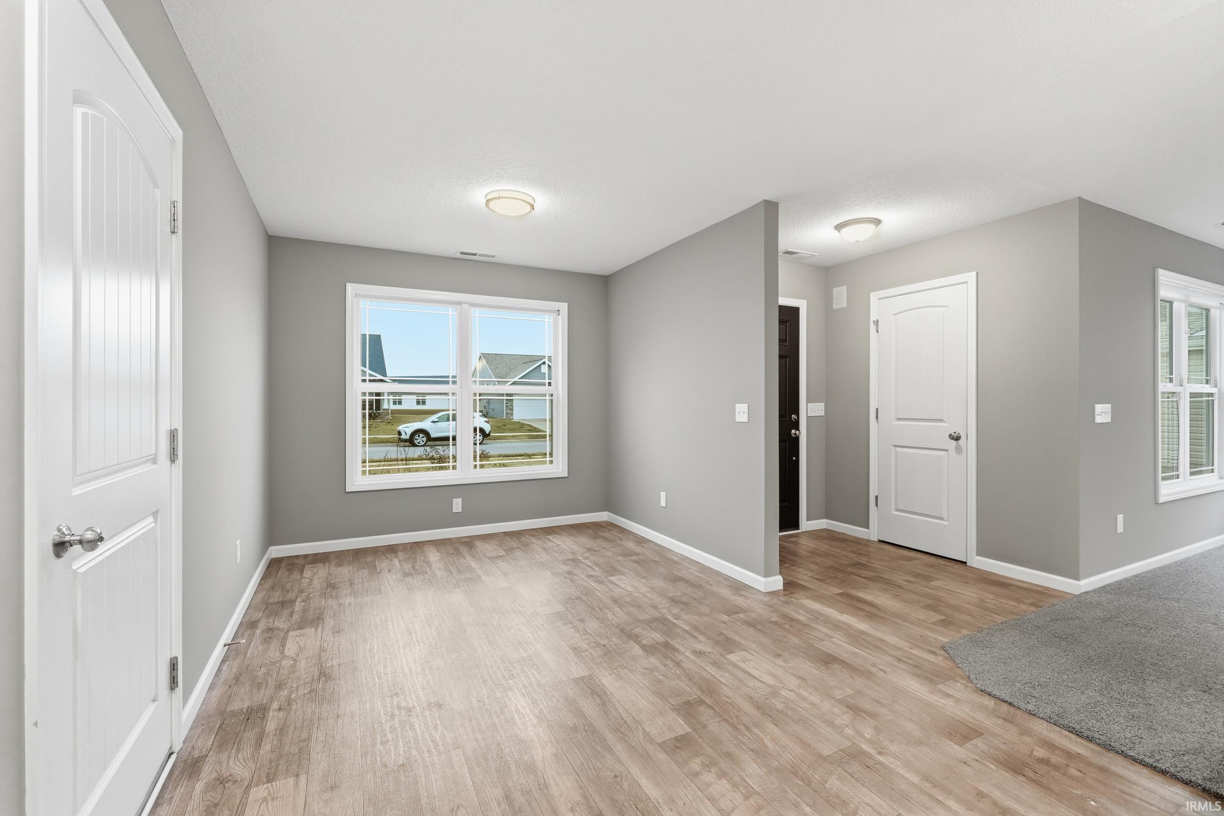 Empty room with light wood-style floors and healthy amount of natural light