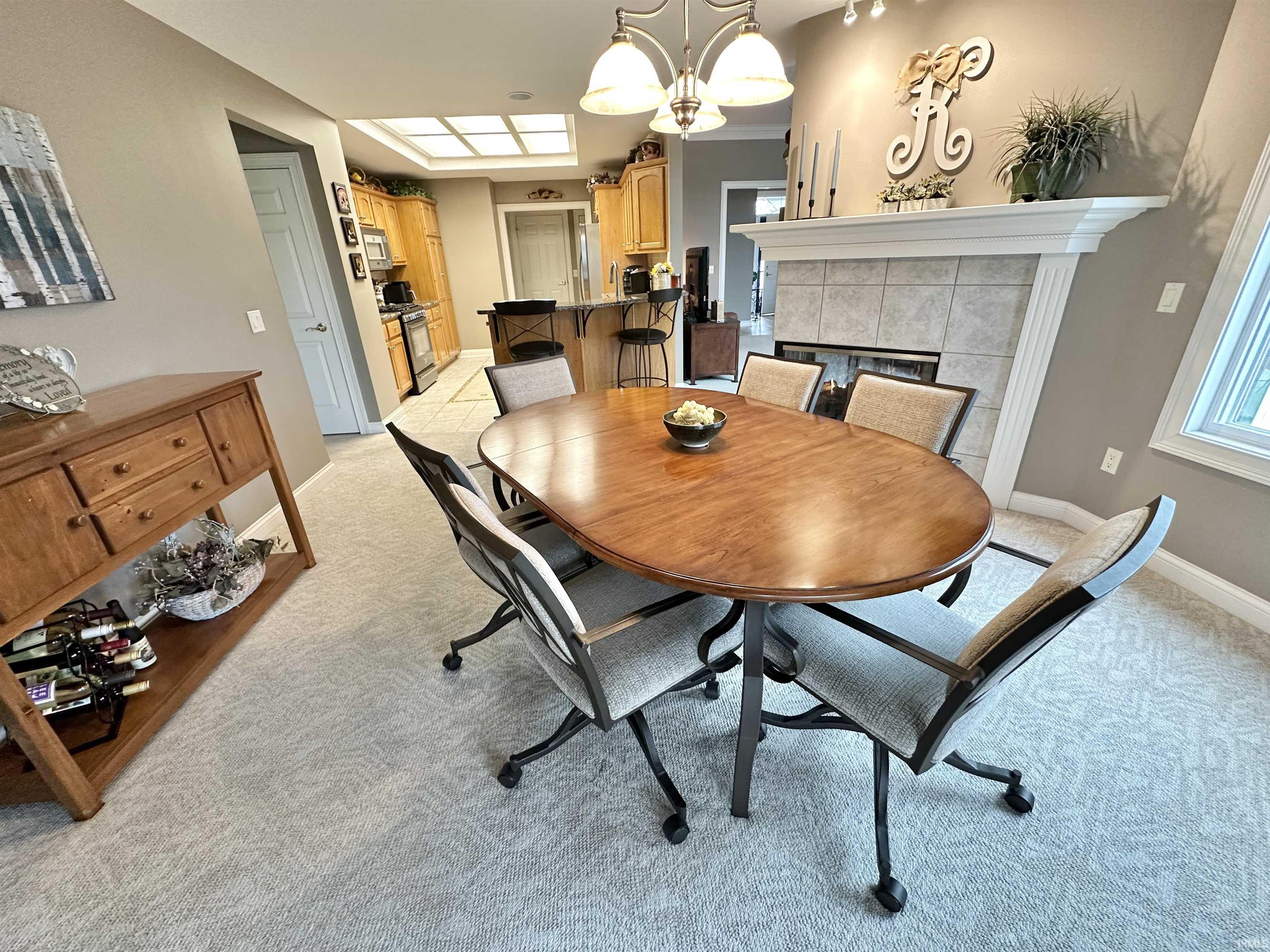 Dining space featuring a chandelier, light carpet, and a fireplace