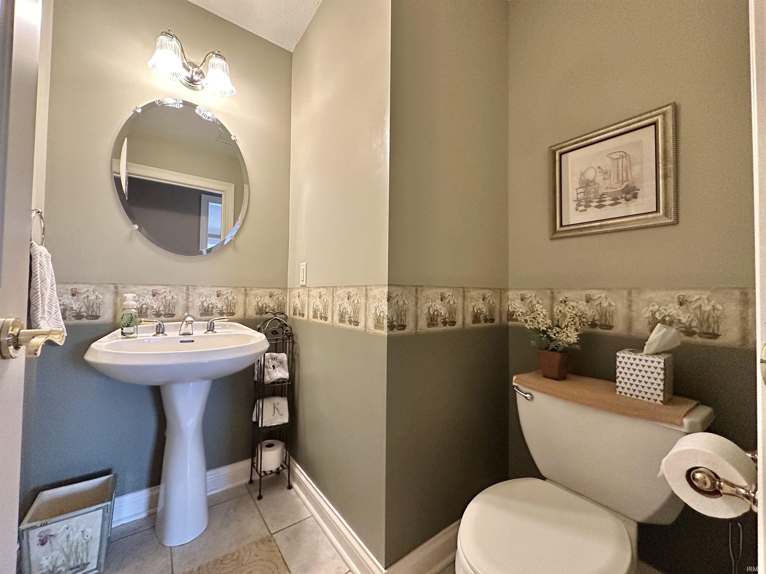 Half bathroom featuring toilet and tile patterned flooring
