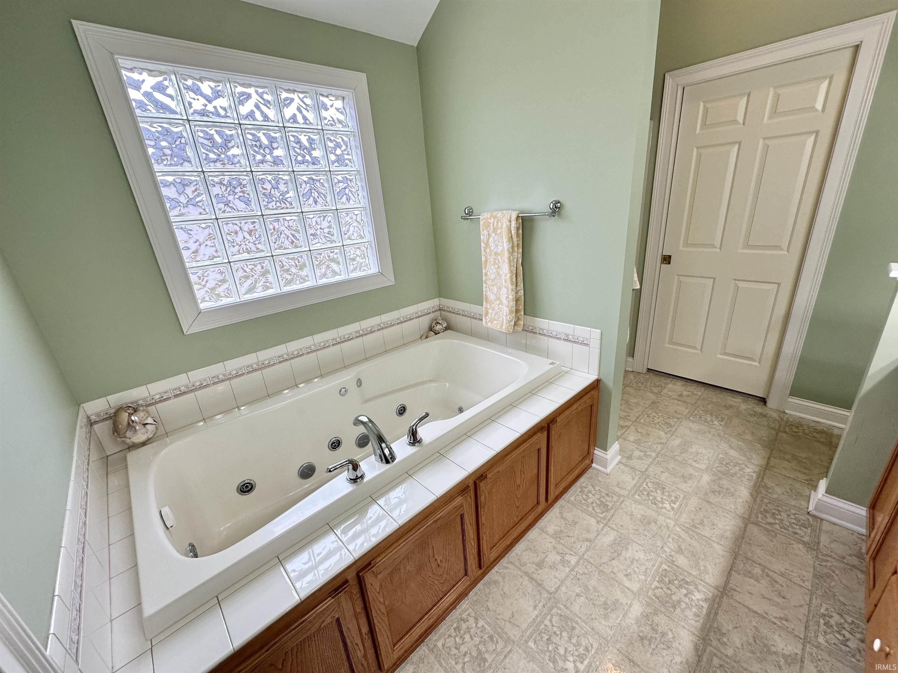 Bathroom with a tub with jets and baseboards