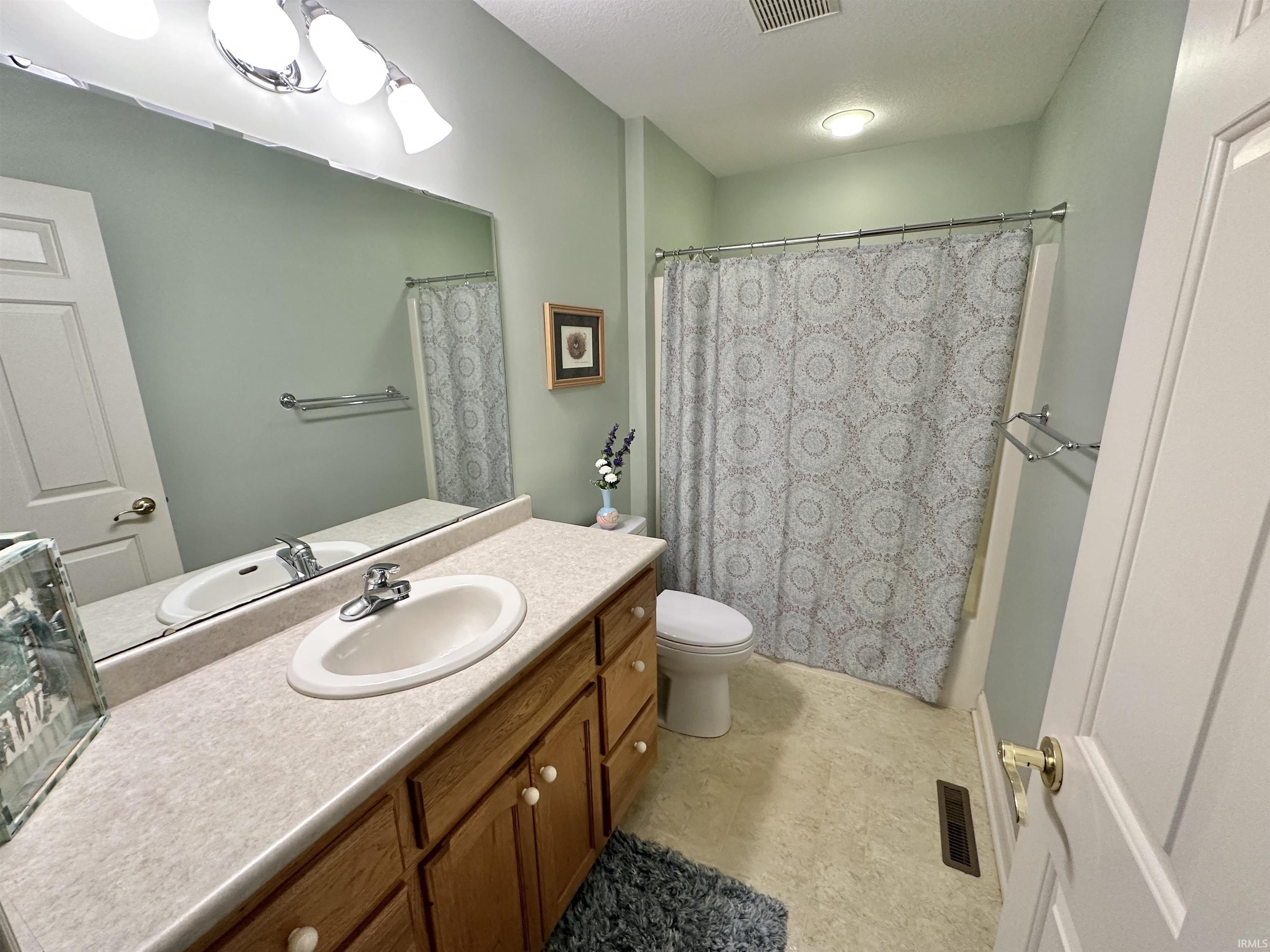 Full bathroom featuring vanity, a textured ceiling, and shower / bath combo