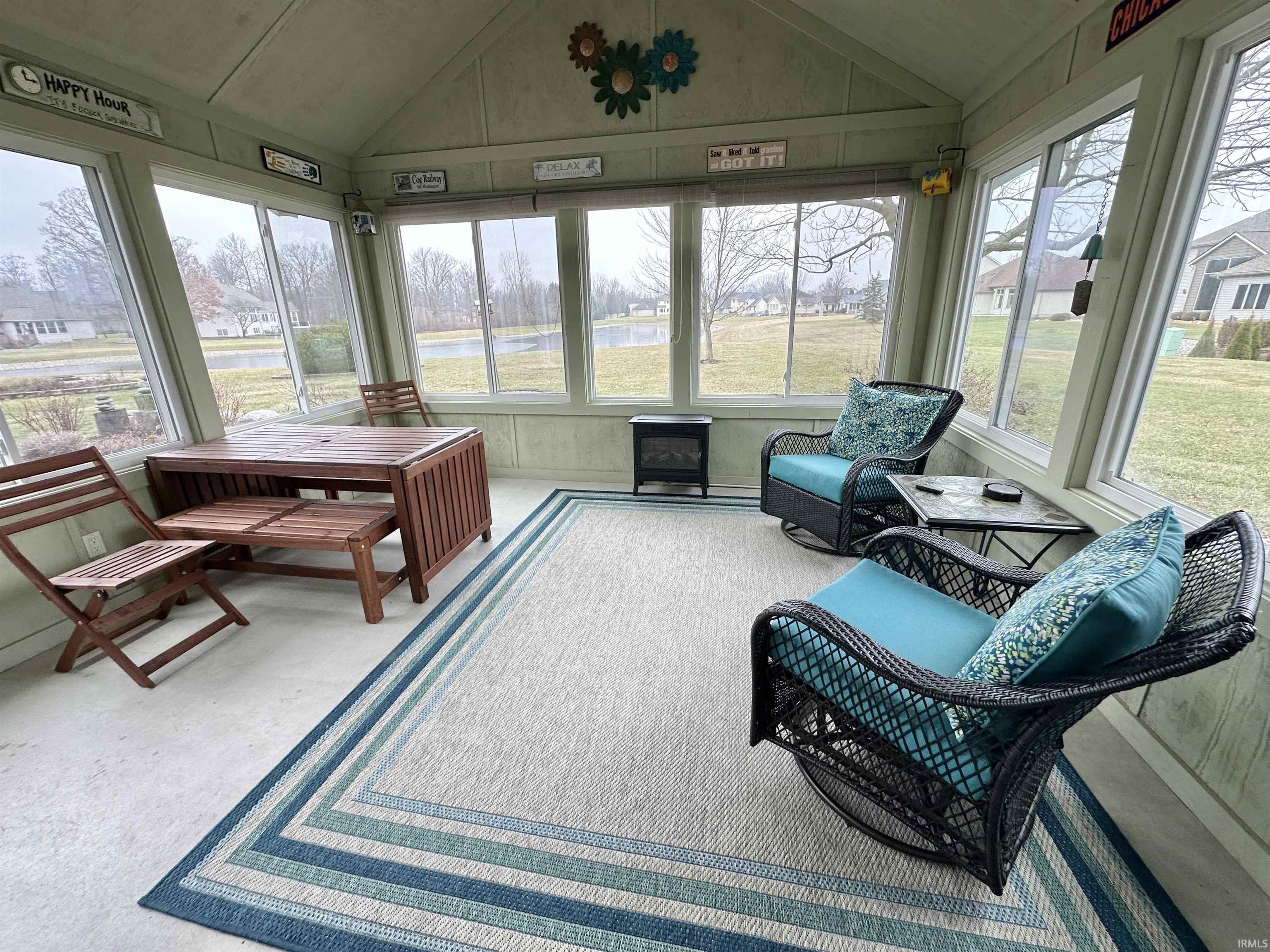 Sunroom / solarium with a water view, lofted ceiling, and healthy amount of natural light
