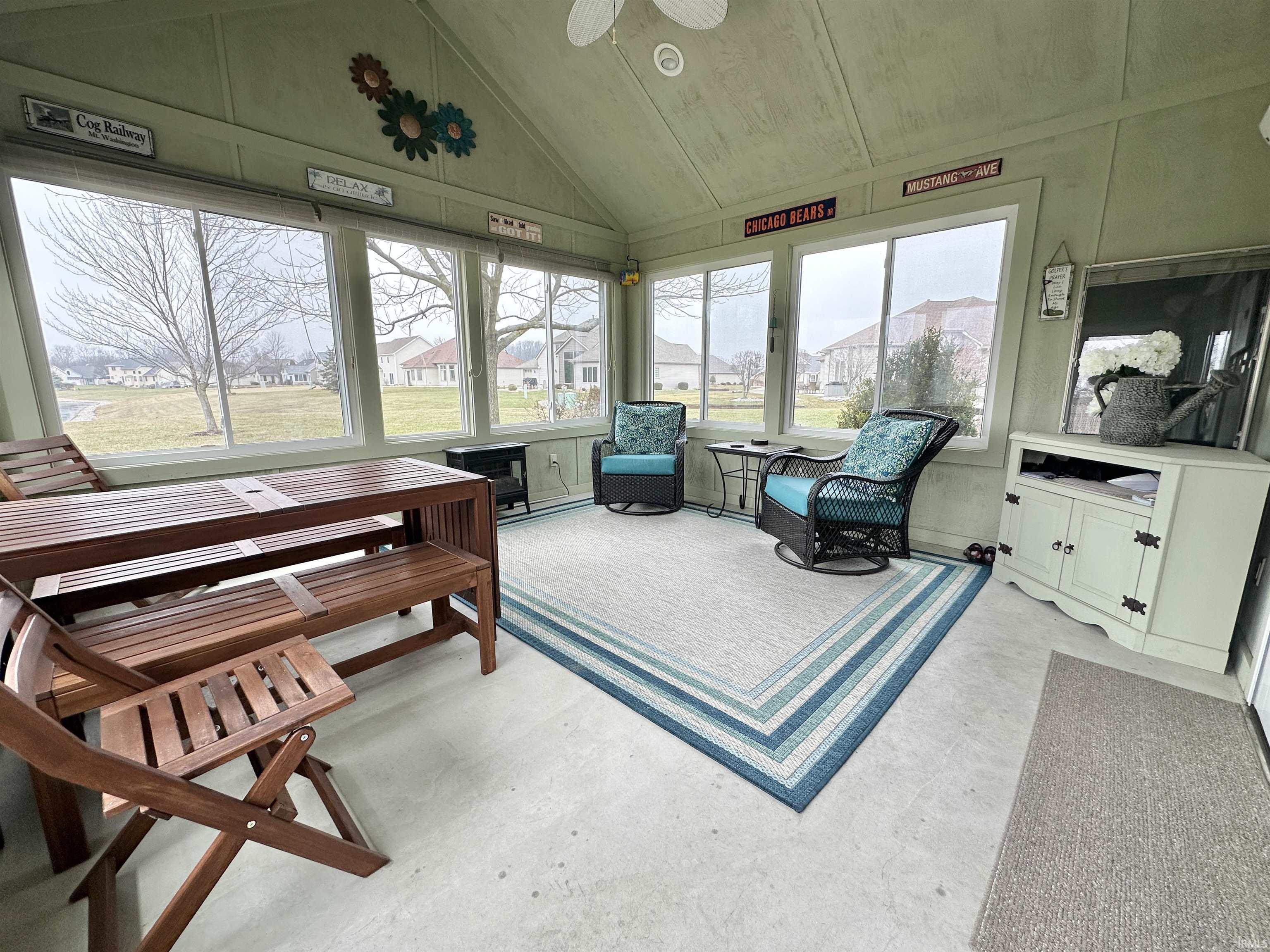 Sunroom featuring lofted ceiling and a decorative wall