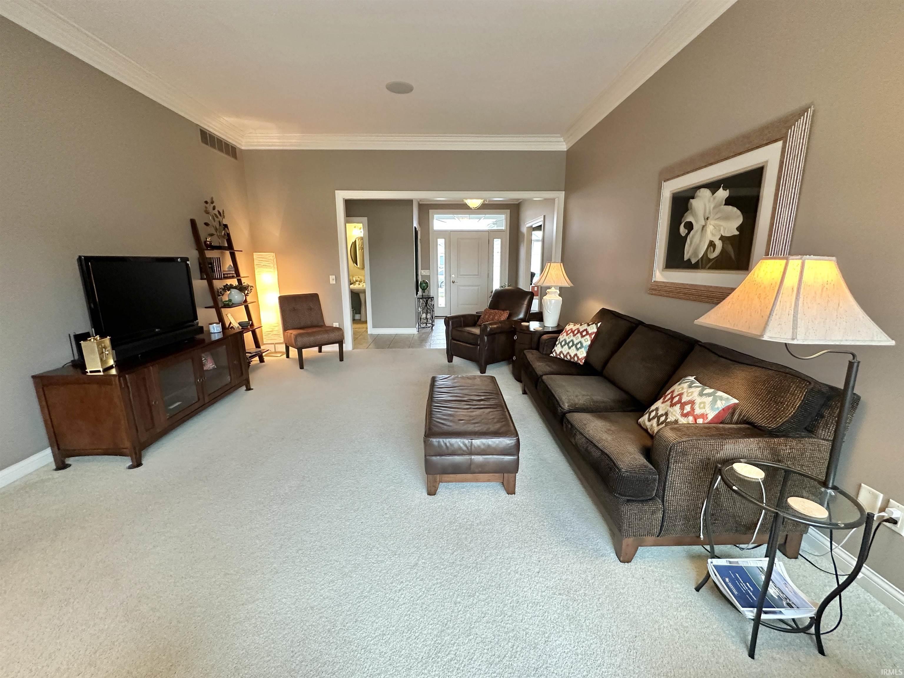 Living room with light carpet and ornamental molding