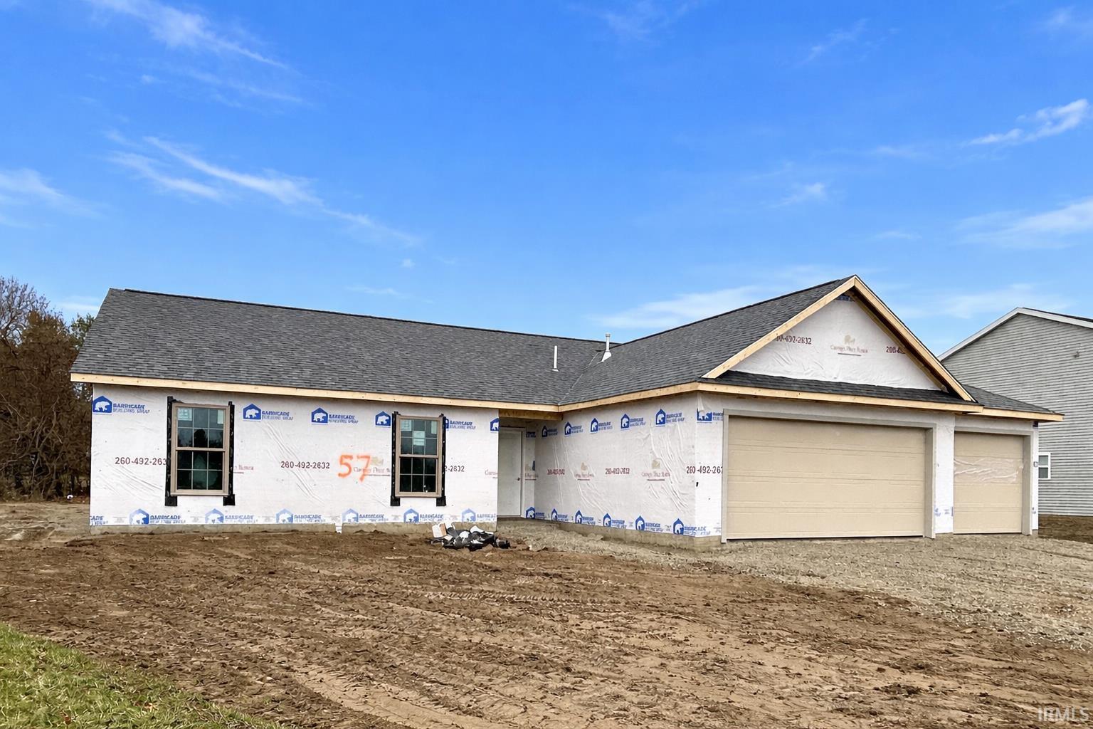 Property in mid-construction featuring driveway, roof with shingles, and a garage