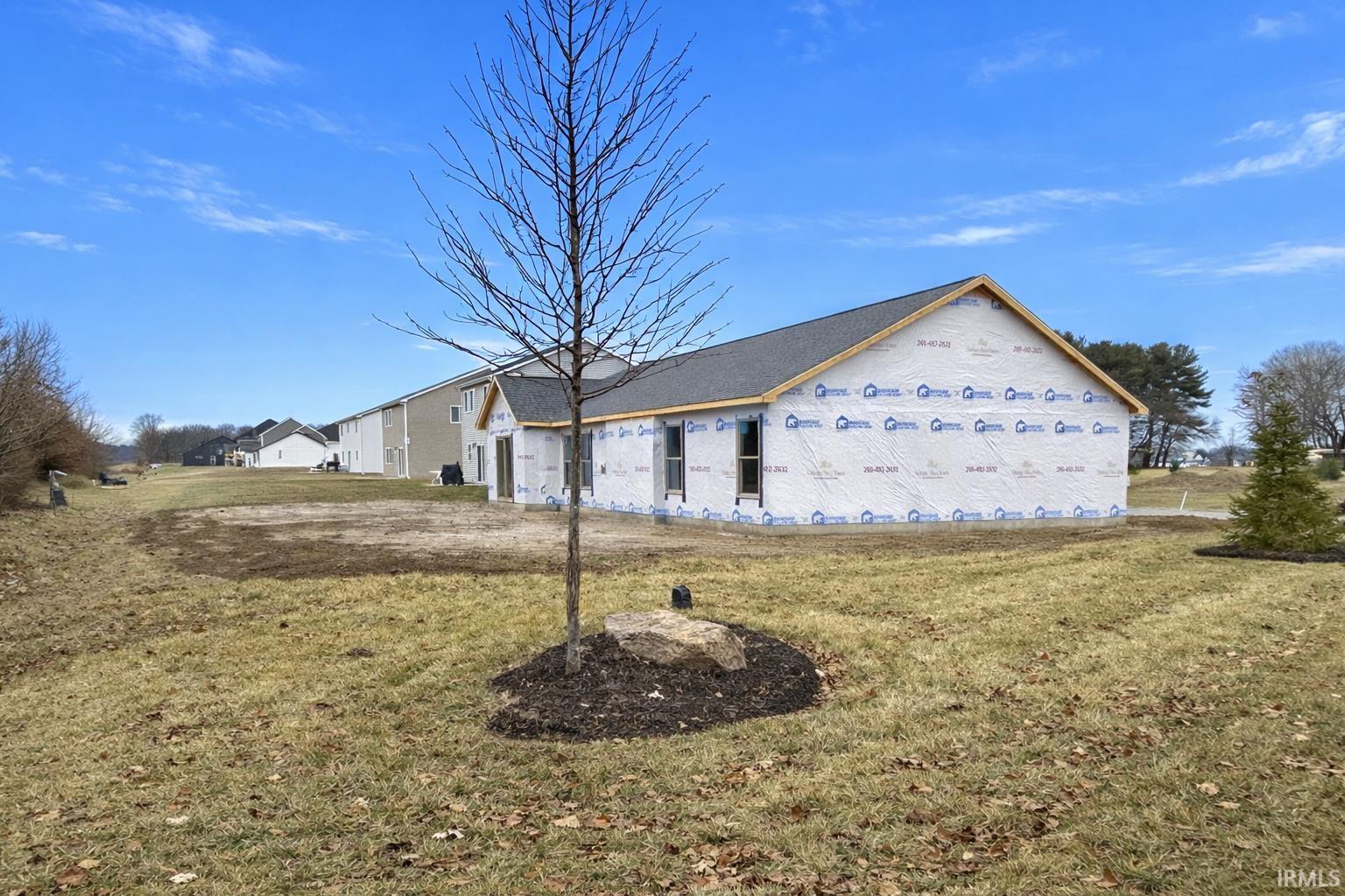 View of side of property with a lawn